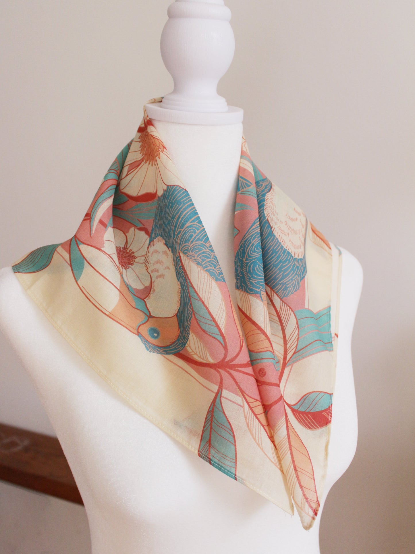 Toucan in floral jungle bandana scarf displayed on mannequin, showcasing soft cotton and vibrant colors.