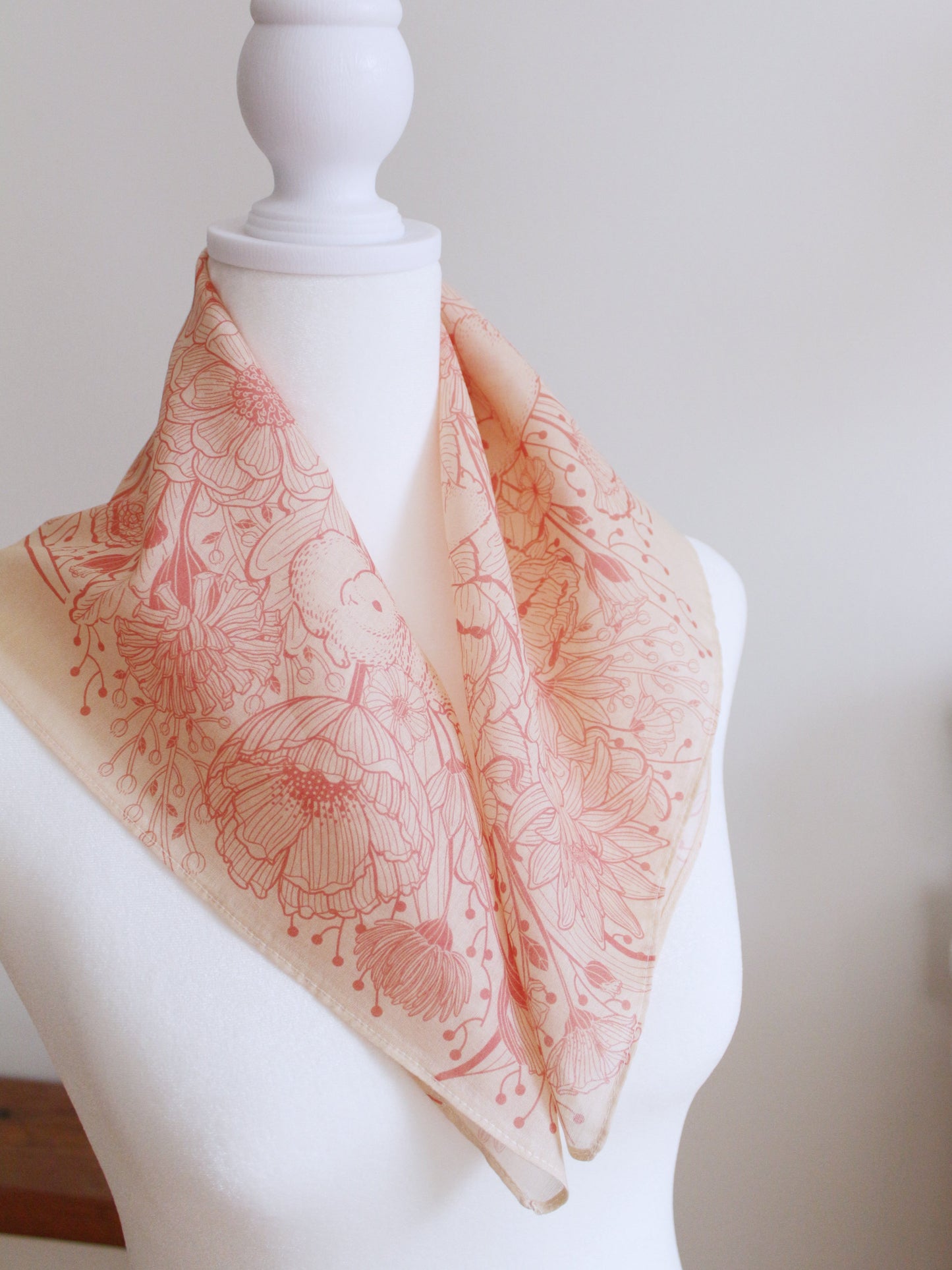 Pastel pink bunny and floral bandana scarf displayed on mannequin, showcasing soft cotton material and intricate design.