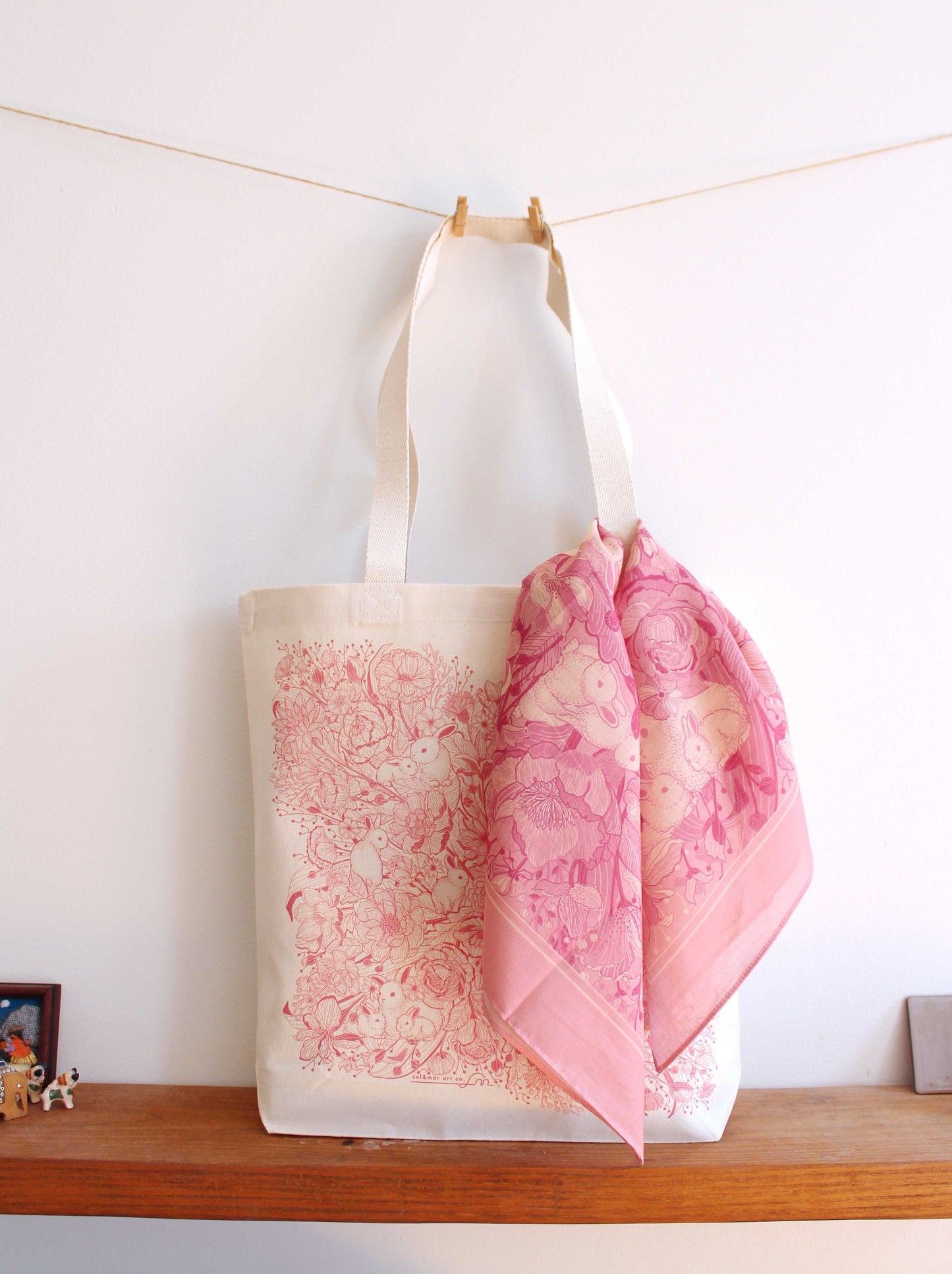 Pink floral bandana scarf styled on a chic tote bag, perfect for summer accessories and décor.