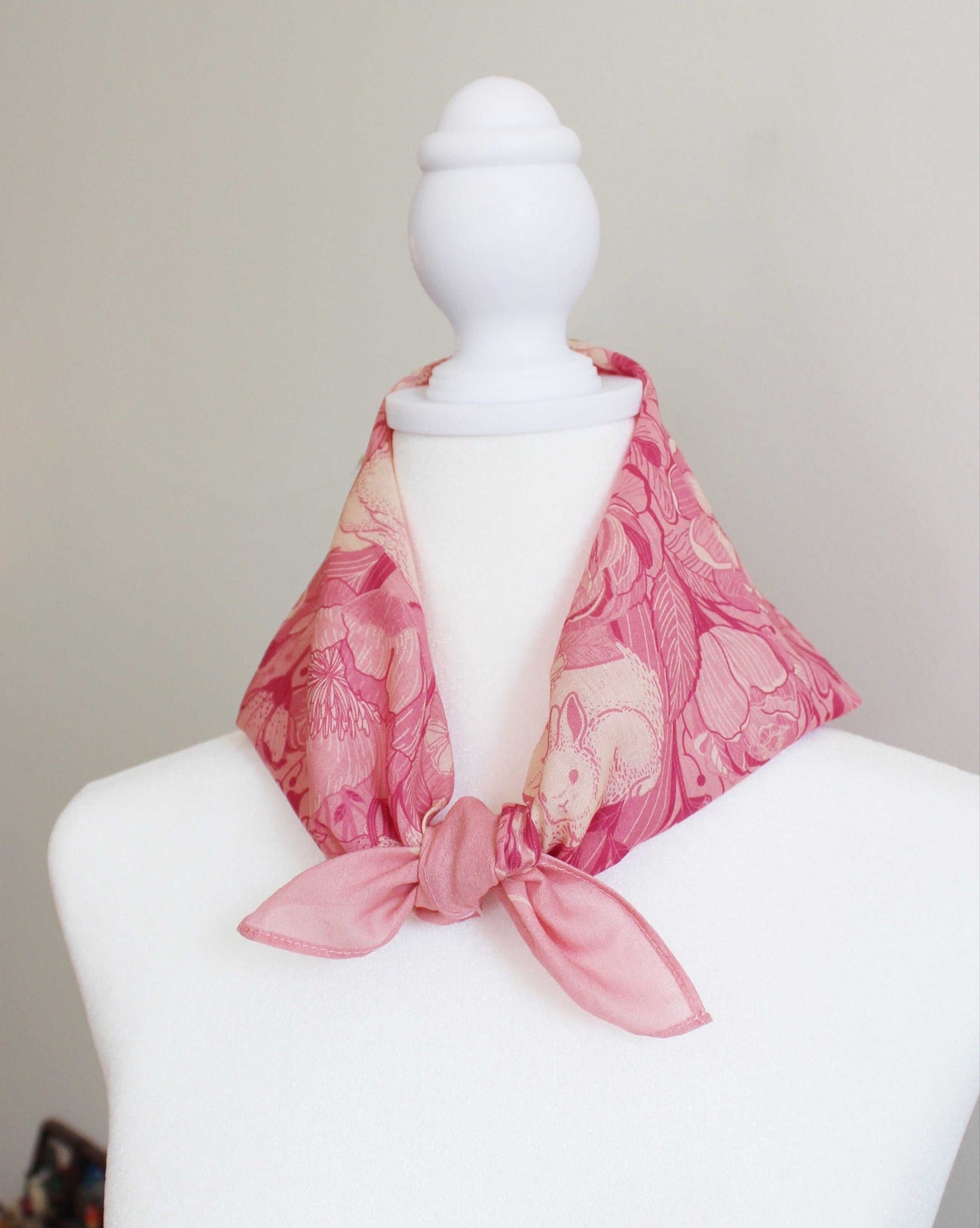 Pink Bunny in the Floral Breeze Bandana Scarf on a mannequin, featuring rabbit and floral artwork.