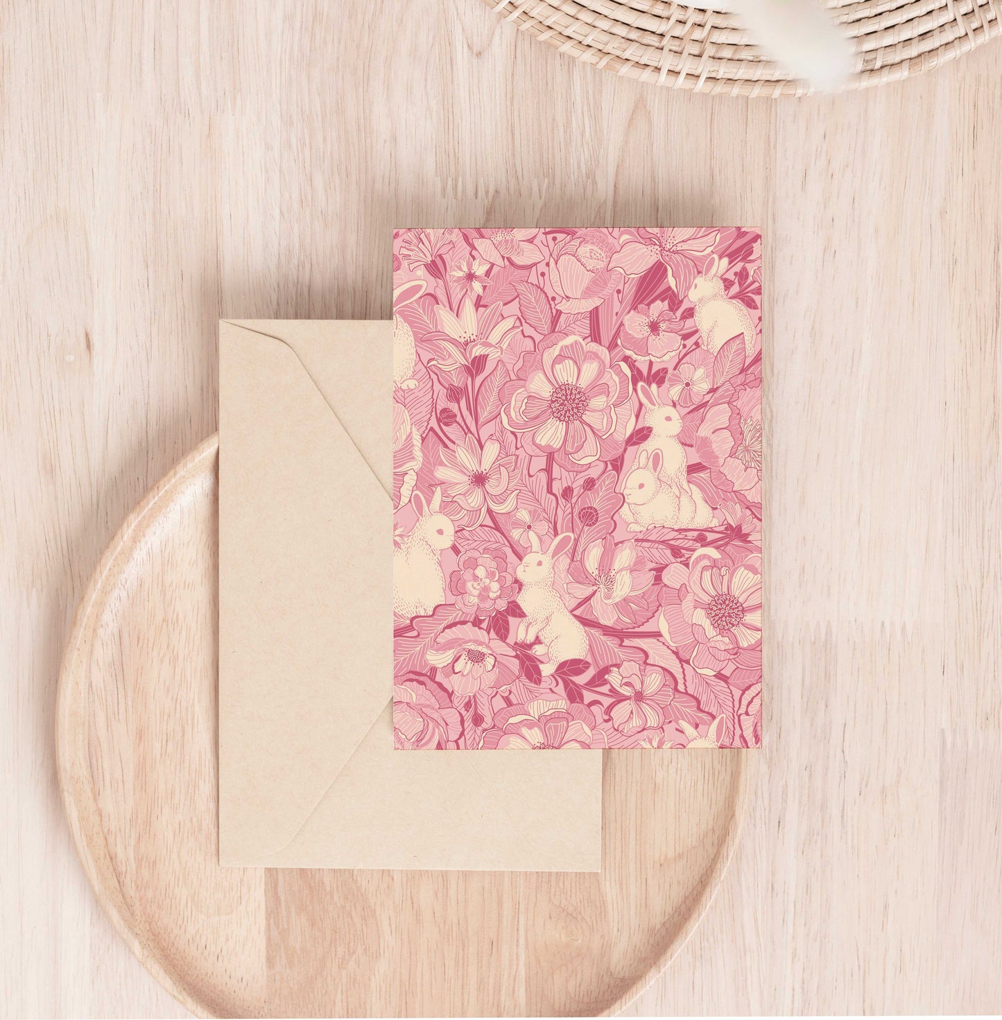 Bunny-themed floral greeting card on a wooden surface with an envelope.