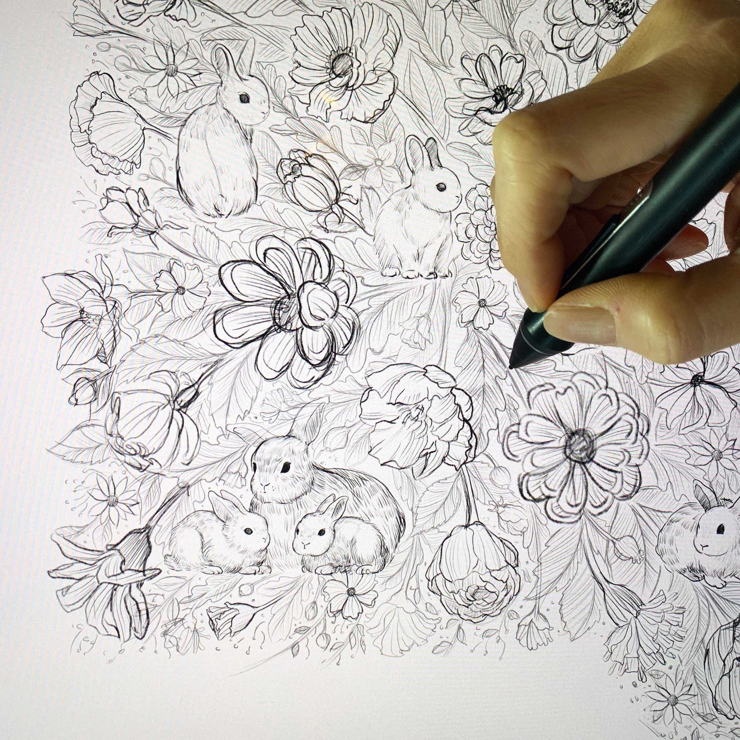 Artist illustrating a detailed floral design featuring rabbits and flowers.