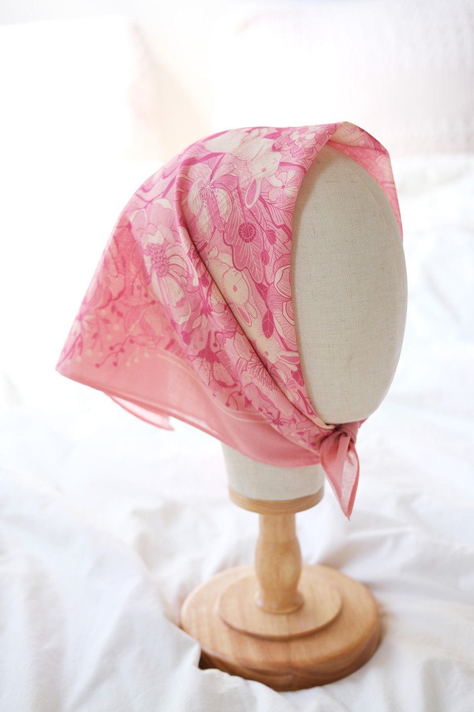 Pink floral bandana scarf featuring a bunny design, perfect for accessories or decor, displayed on a mannequin head.