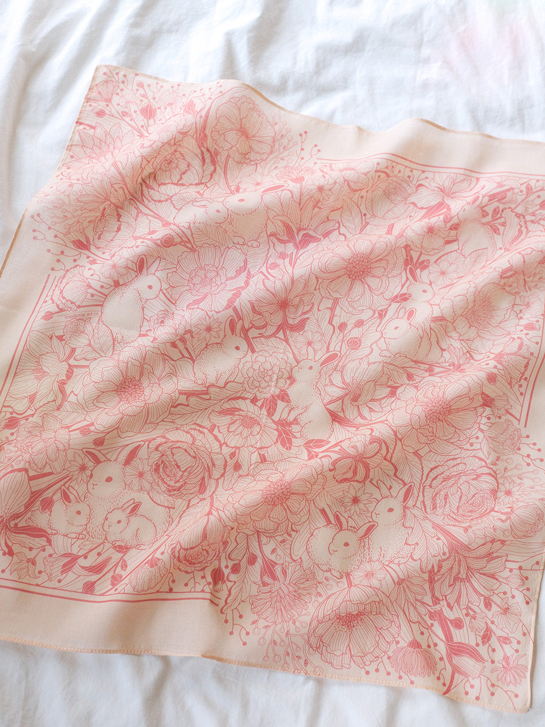 Pastel pink bandana scarf featuring illustrated bunnies and flowers, soft cotton accessory for year-round style.