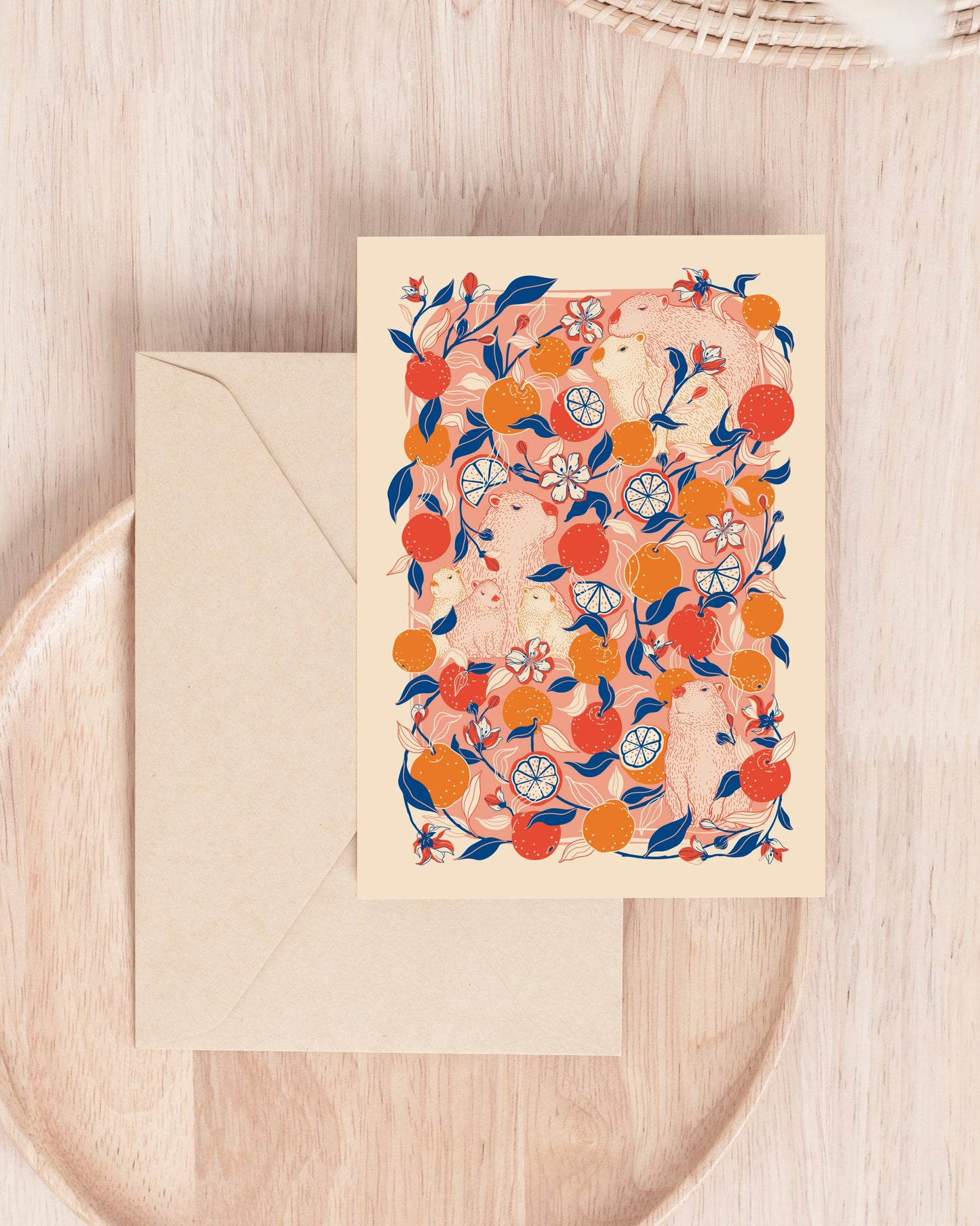 Greeting capybara card with floral design on a wooden surface