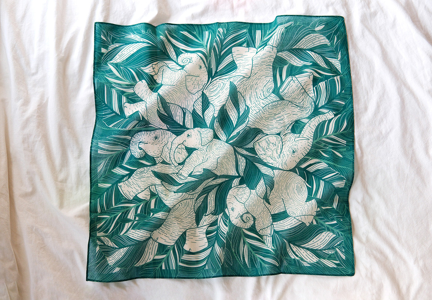 Green bandana scarf featuring illustrated elephants napping among jungle leaves, perfect as a versatile accessory.