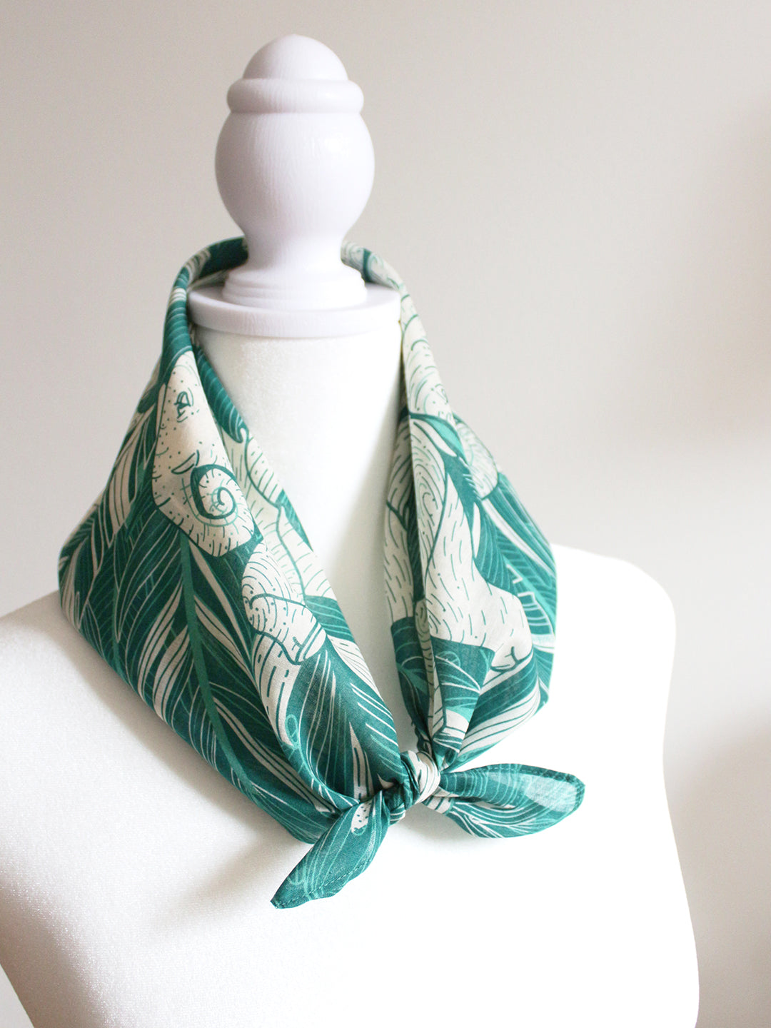 Green Elephant 'Siesta' Bandana Scarf tied around a display neck, showcasing jungle-themed artwork.