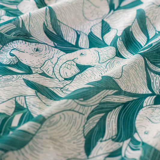 Close-up of green 'Siesta' bandana scarf depicting elephants and jungle leaves design.