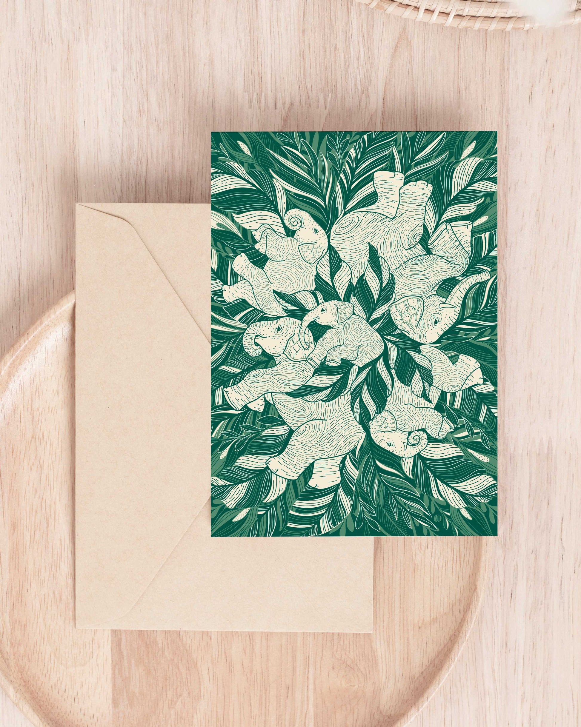 Green 'Siesta' bandana scarf with elephants and jungle leaves design on wooden surface.