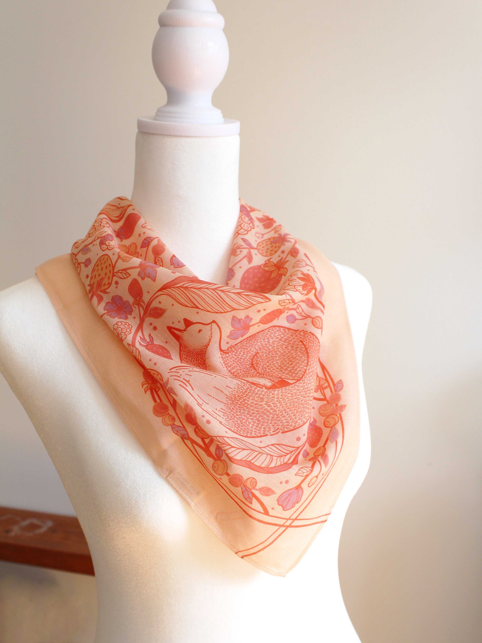 Fox&Berry blush bandana scarf featuring illustrated red foxes and berries, styled on a dress form.