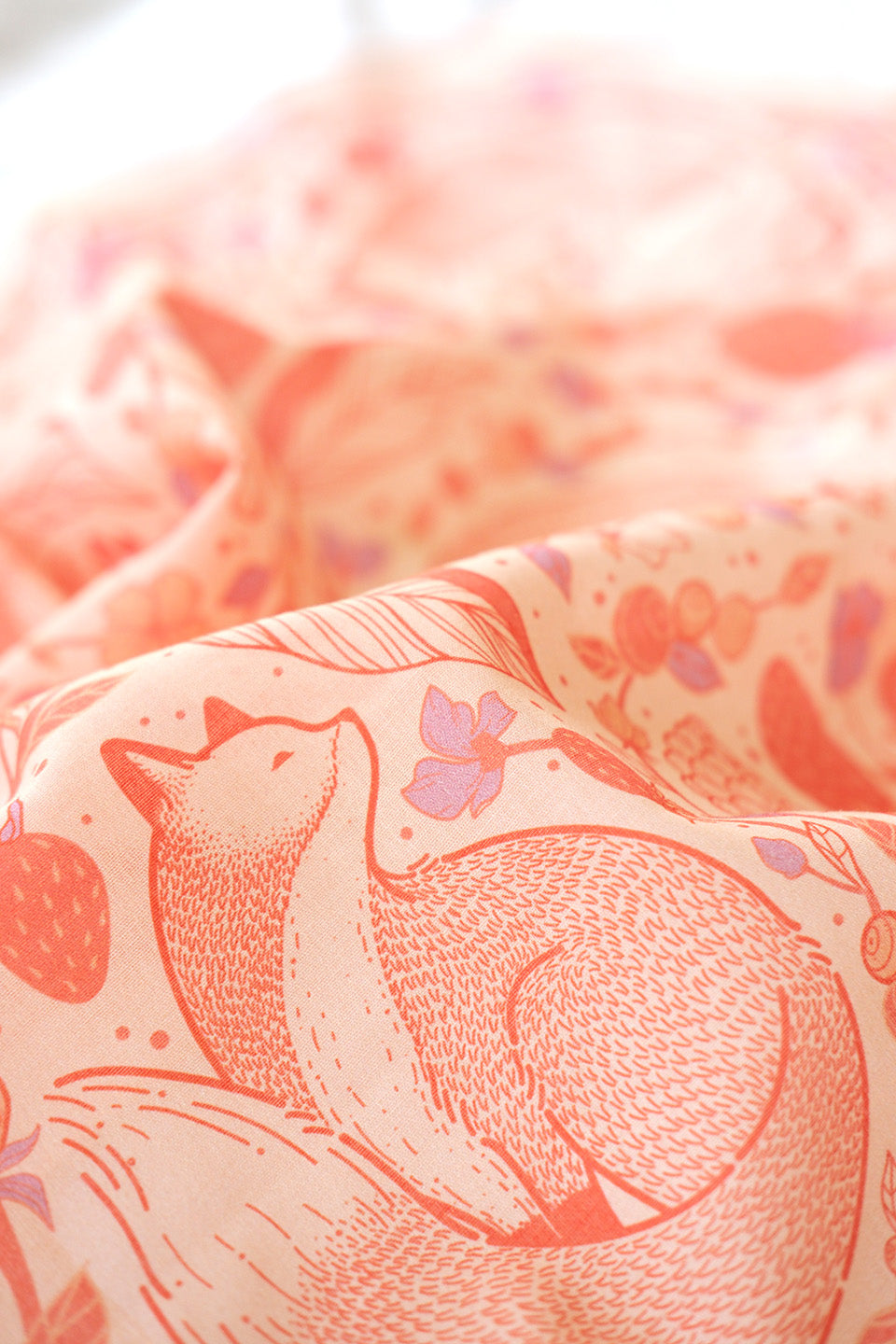 Close-up of Fox&Berry blush bandana scarf featuring illustrated red foxes and berries on soft cotton fabric.