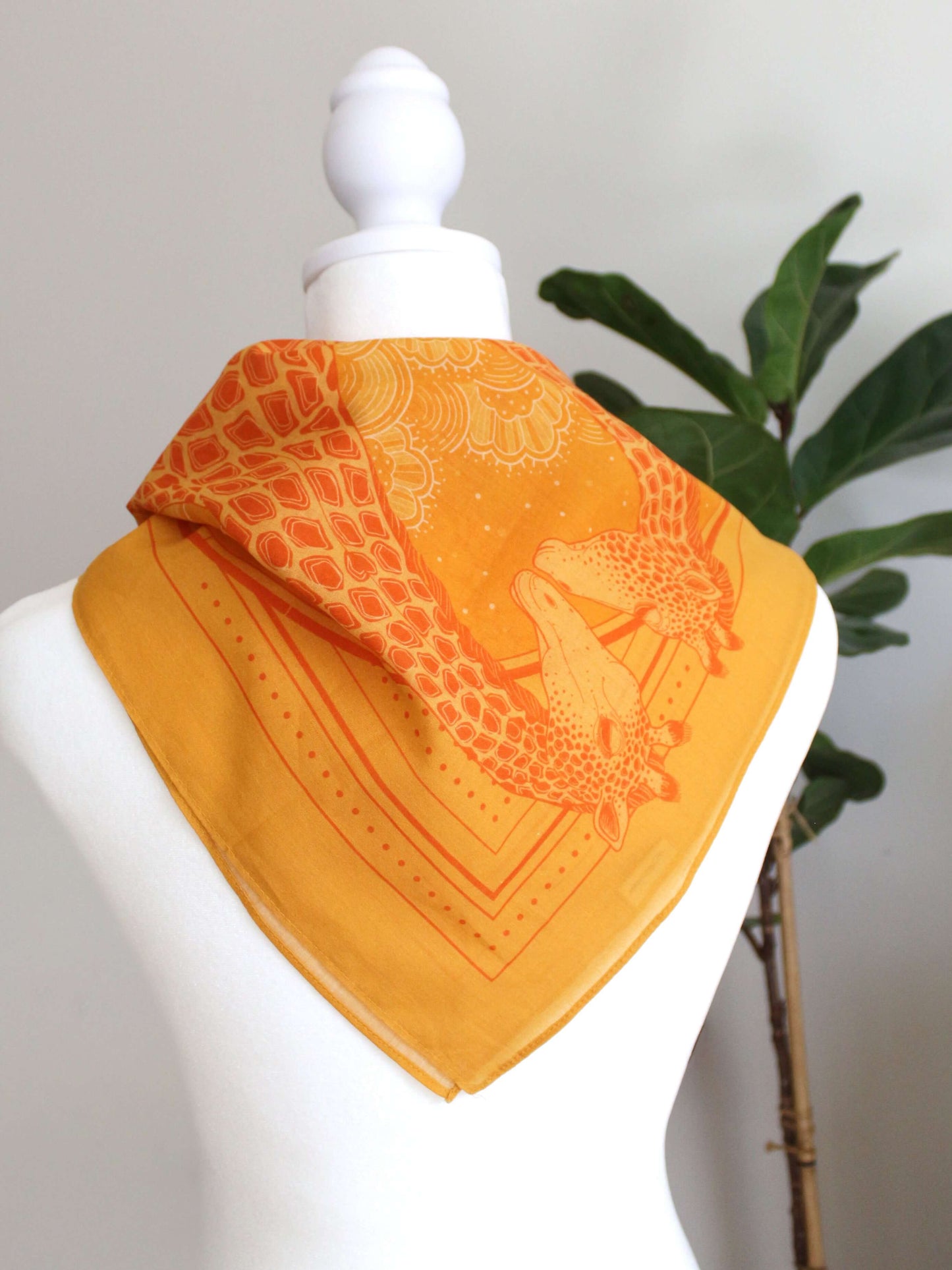 Golden yellow bandana scarf featuring a giraffe family design, perfect for summer accessories.