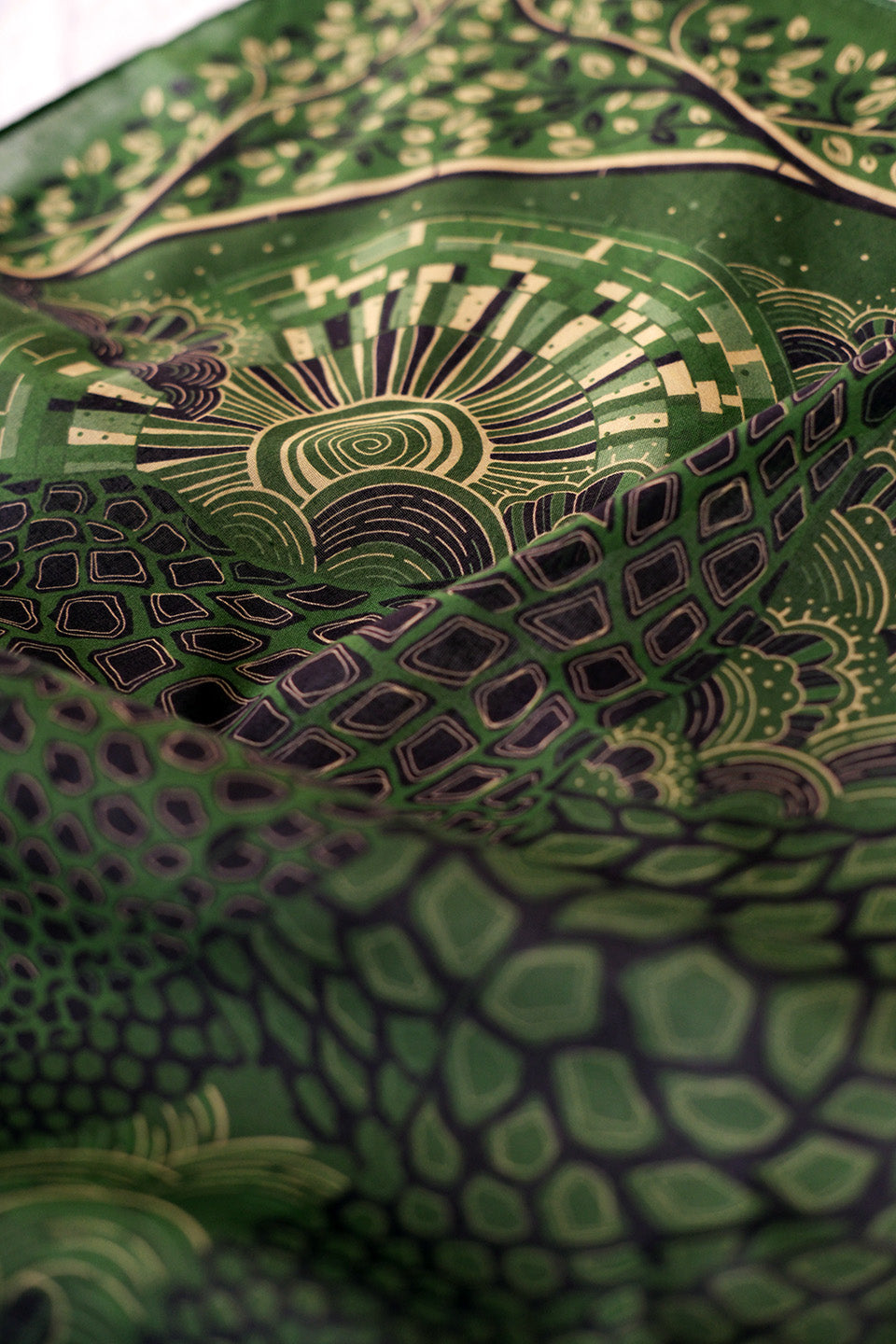 Olive green bandana scarf featuring intricate patterns inspired by nature and art, perfect for versatile styling.