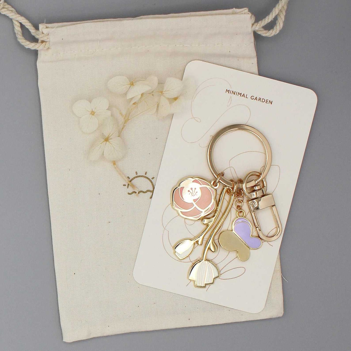 Minimal Garden Keychain featuring gold plated flower and butterfly charms on a display card.