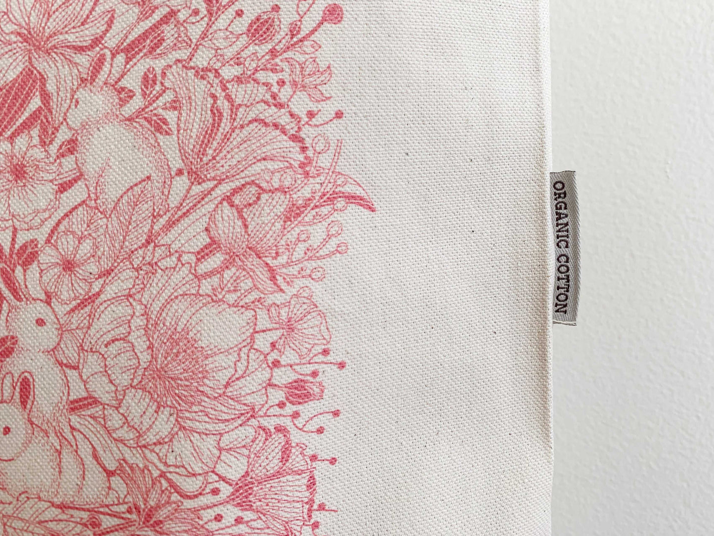 Bunny and floral design on organic cotton canvas tote bag, showcasing vibrant artwork and eco-friendly label.