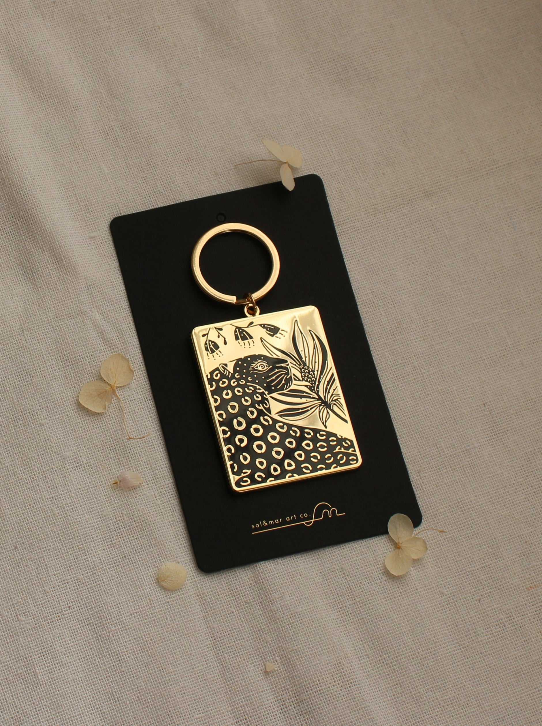 Gold-plated leopard and flowers enamel keychain on a black card, featuring a stylish design with a circular keyring.