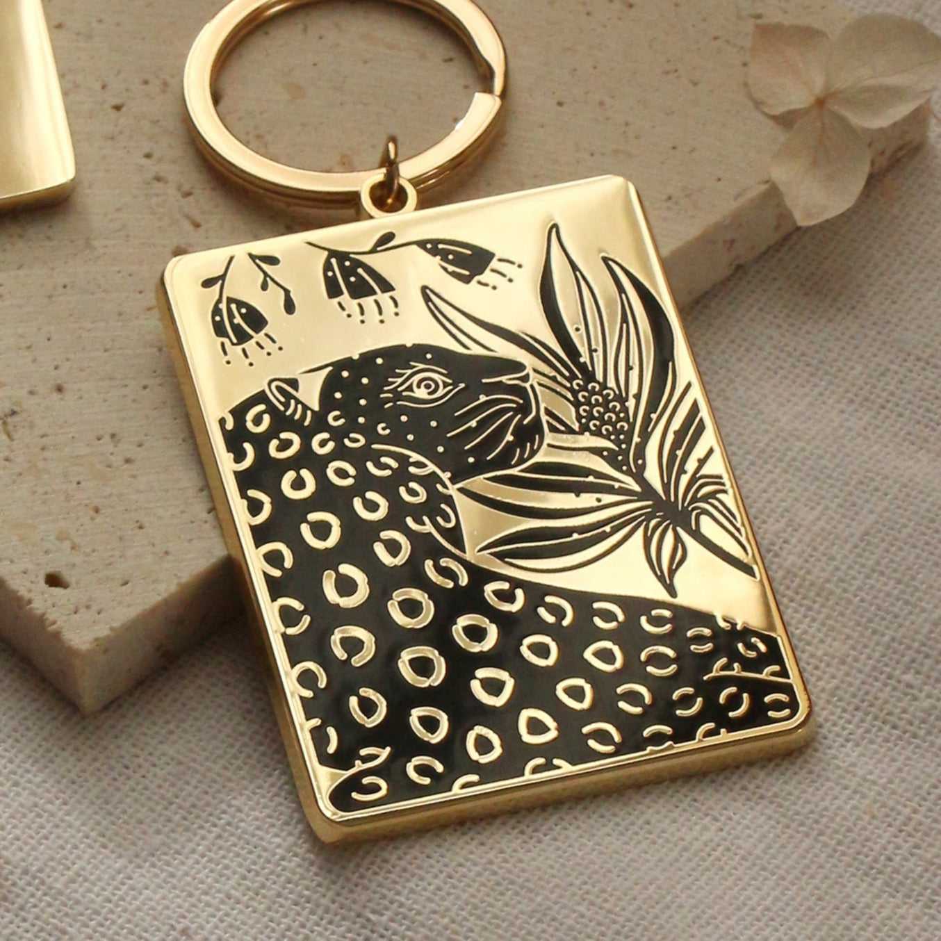 Gold-plated enamel keychain featuring a leopard and floral design, perfect for bags and purses.