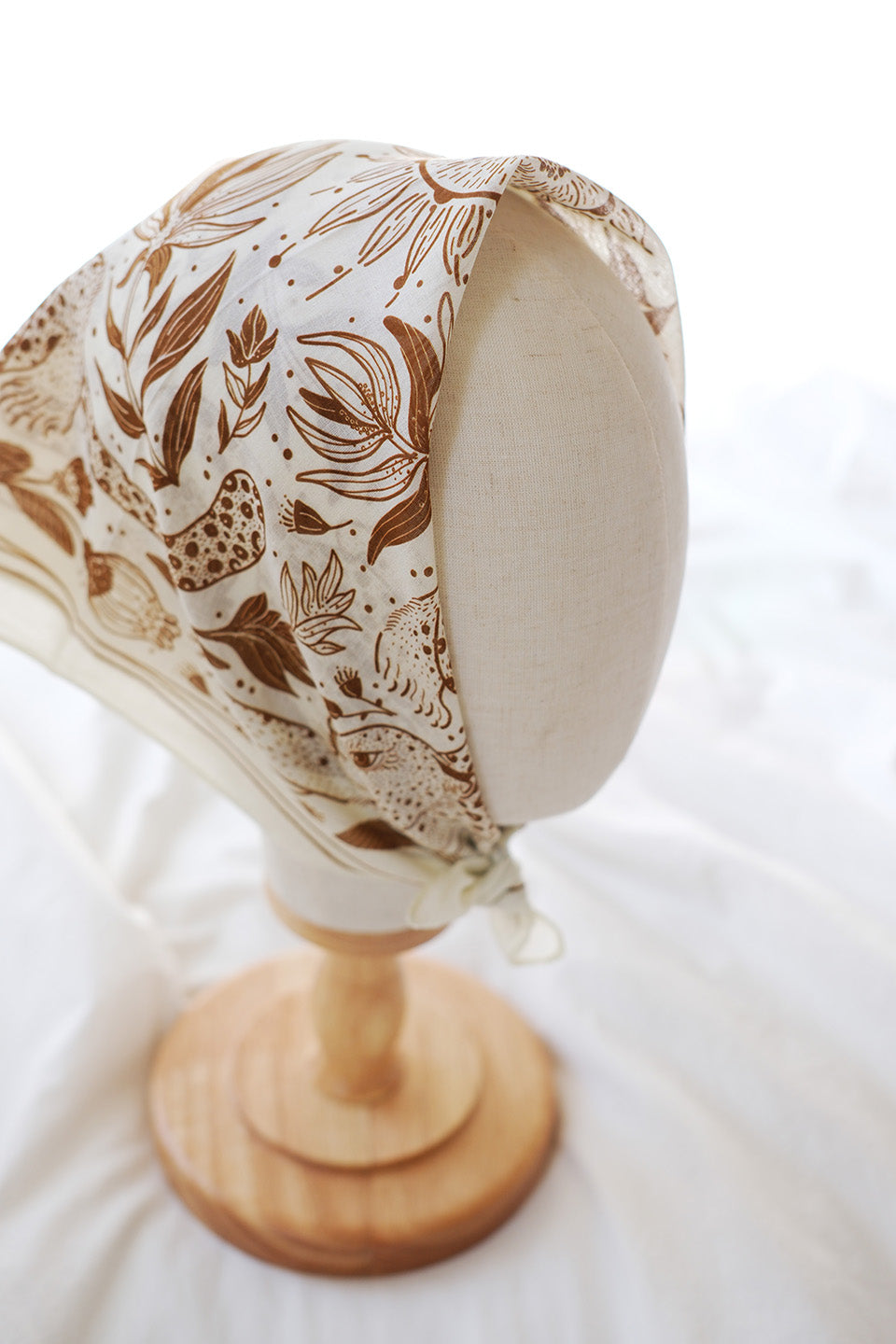 Leopard and the Sun Bandana Scarf displayed on a mannequin, featuring off-white fabric with line art design.