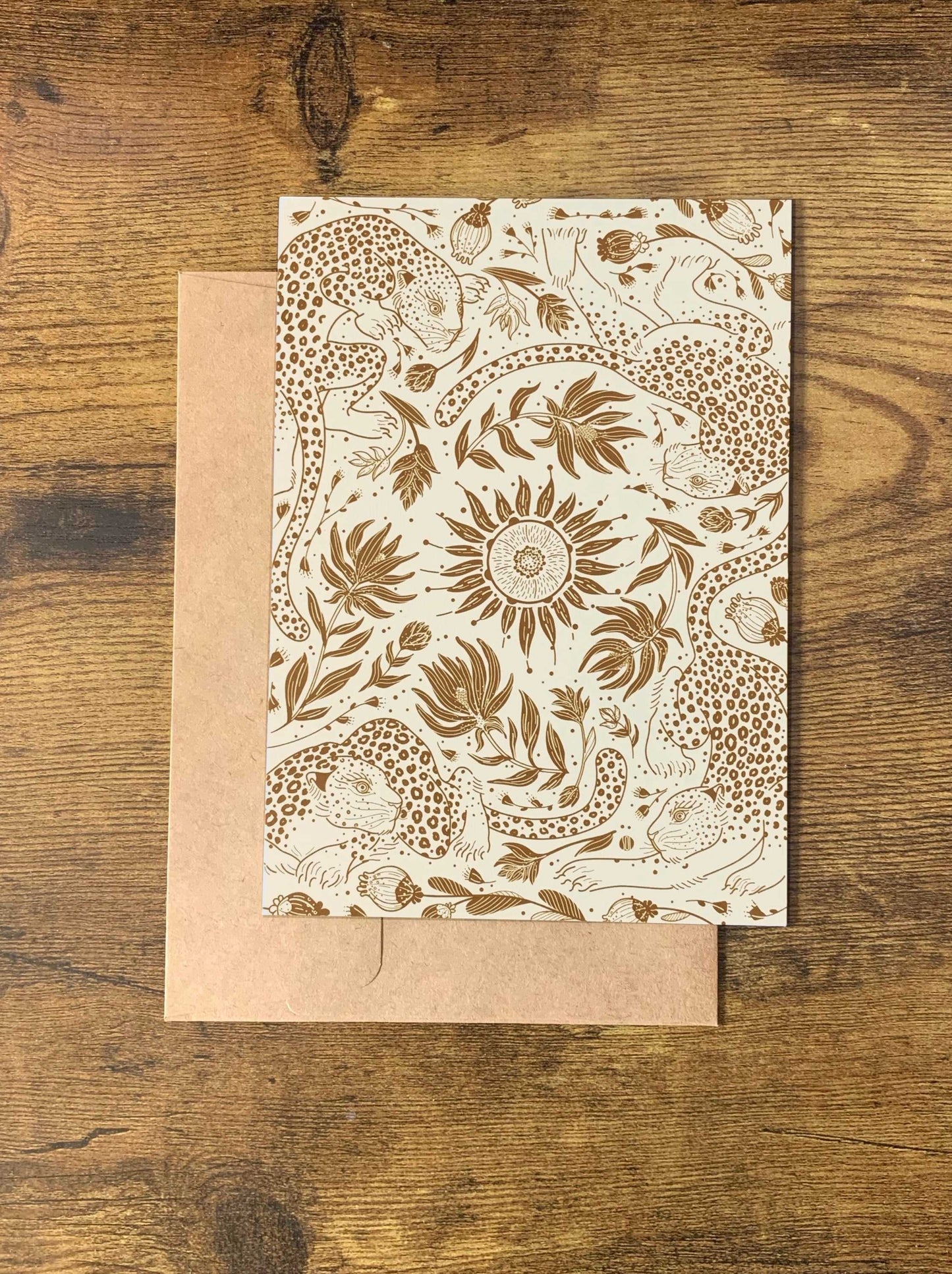 Leopard and the Sun patterned note card with floral designs on a wooden surface.