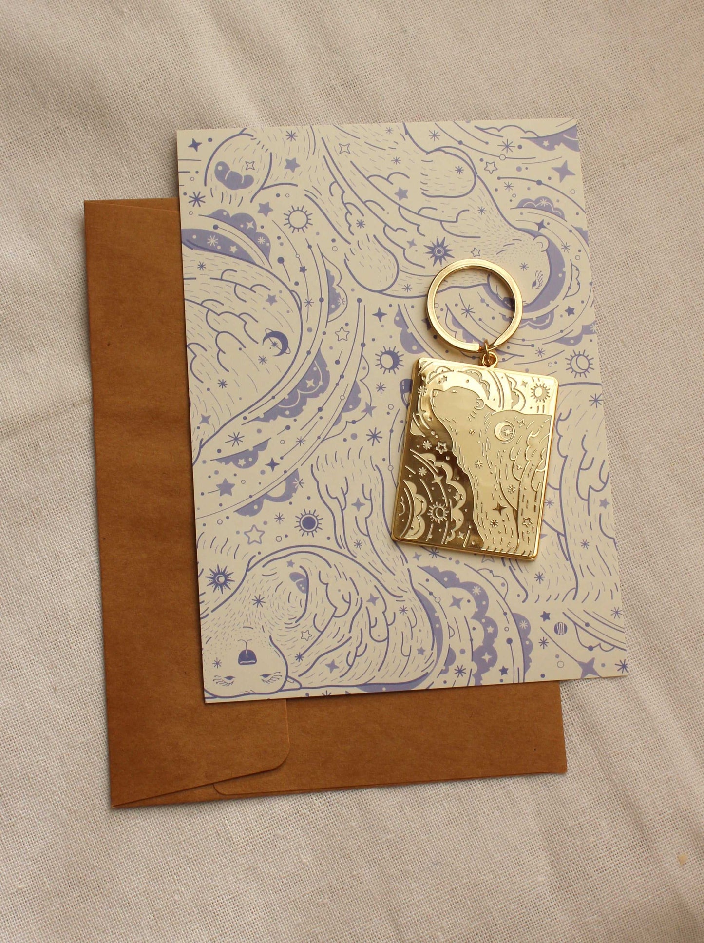 Gold-plated Polar Bear enamel keychain on a decorative display card with a brown envelope.