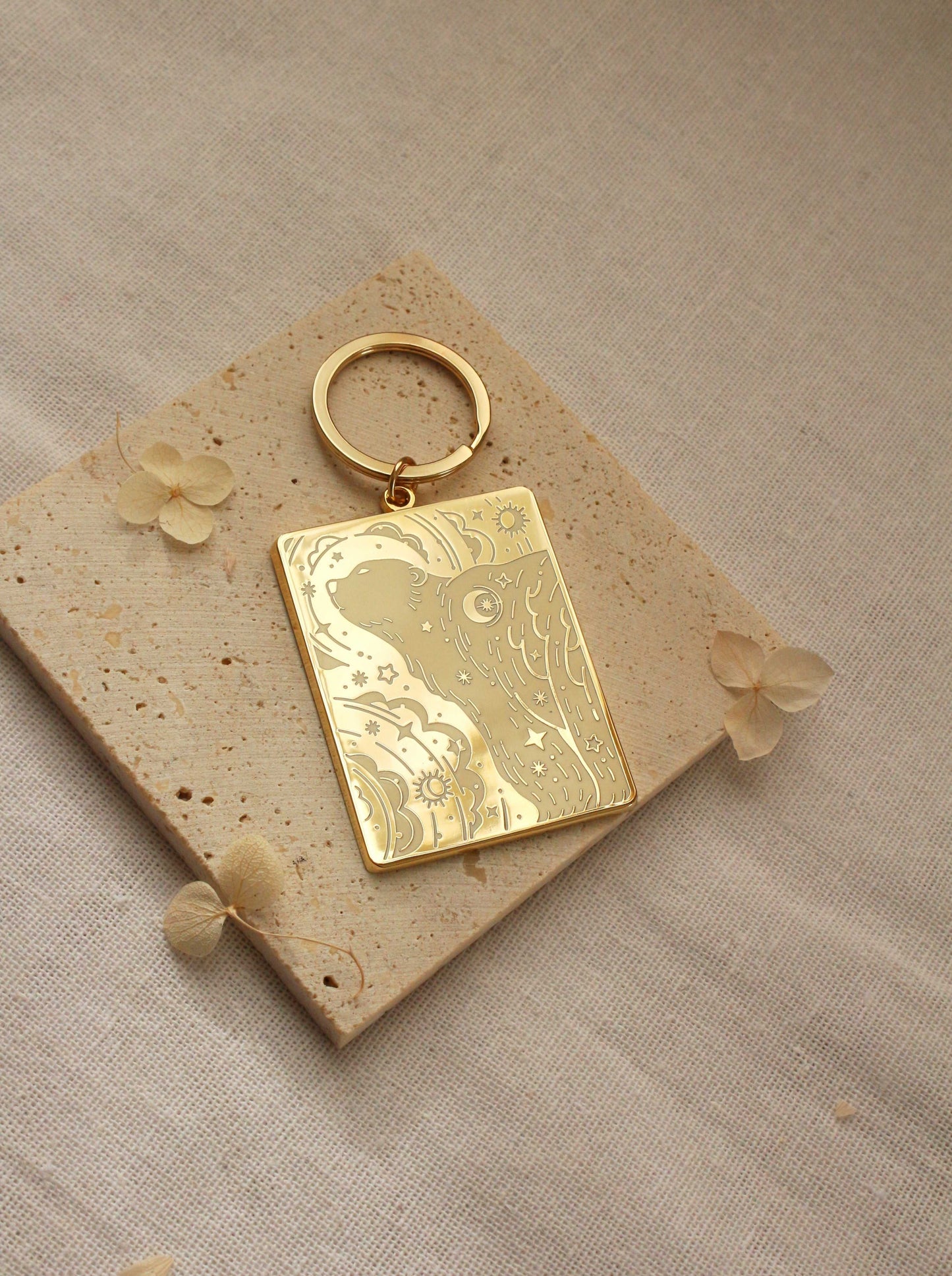 Gold-plated rectangle enamel keychain featuring a polar bear and northern sky design on a textured surface.