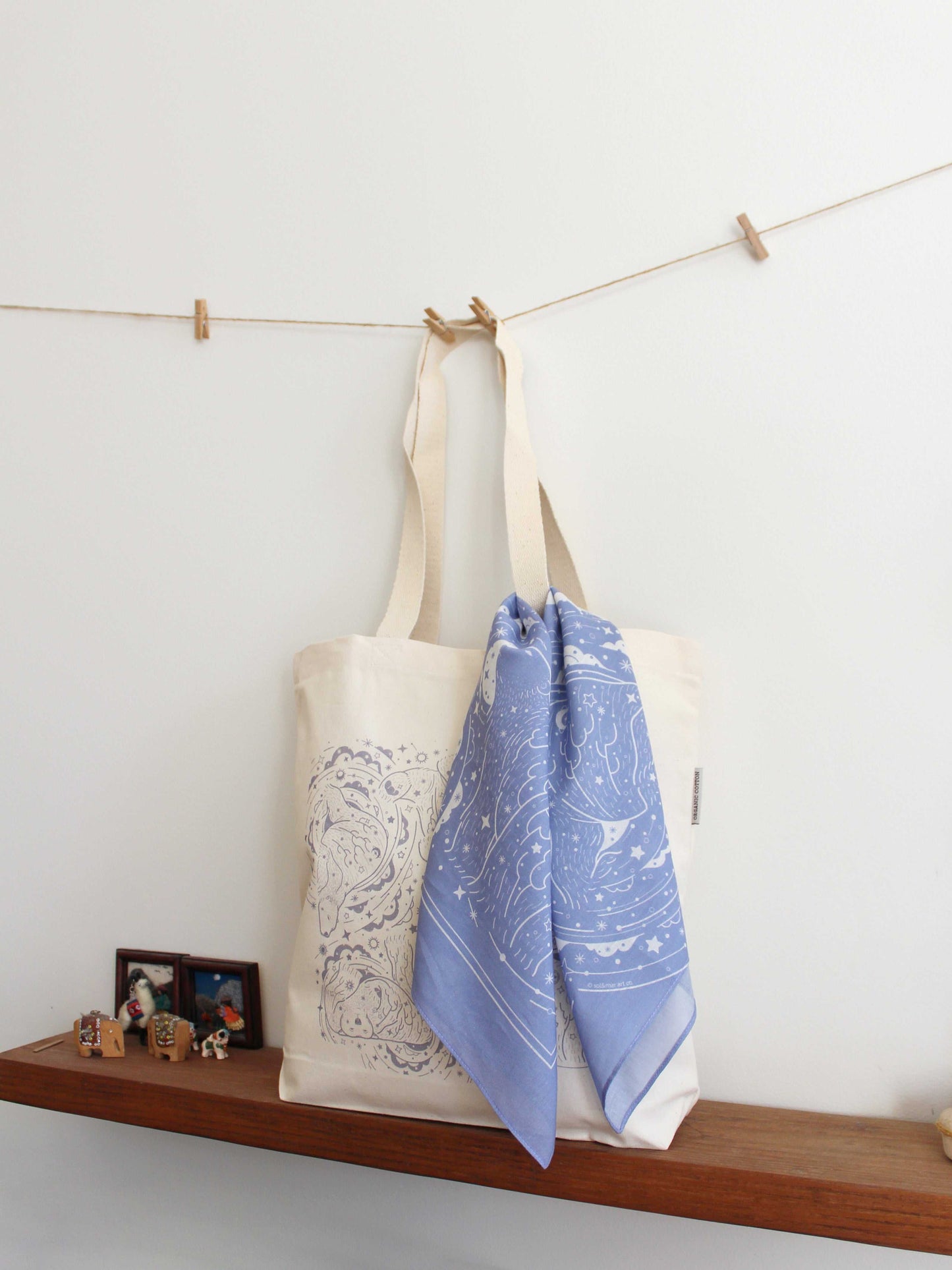 Lavender bandana scarf draped on a natural tote bag, showcasing a starry Northern Sky design.