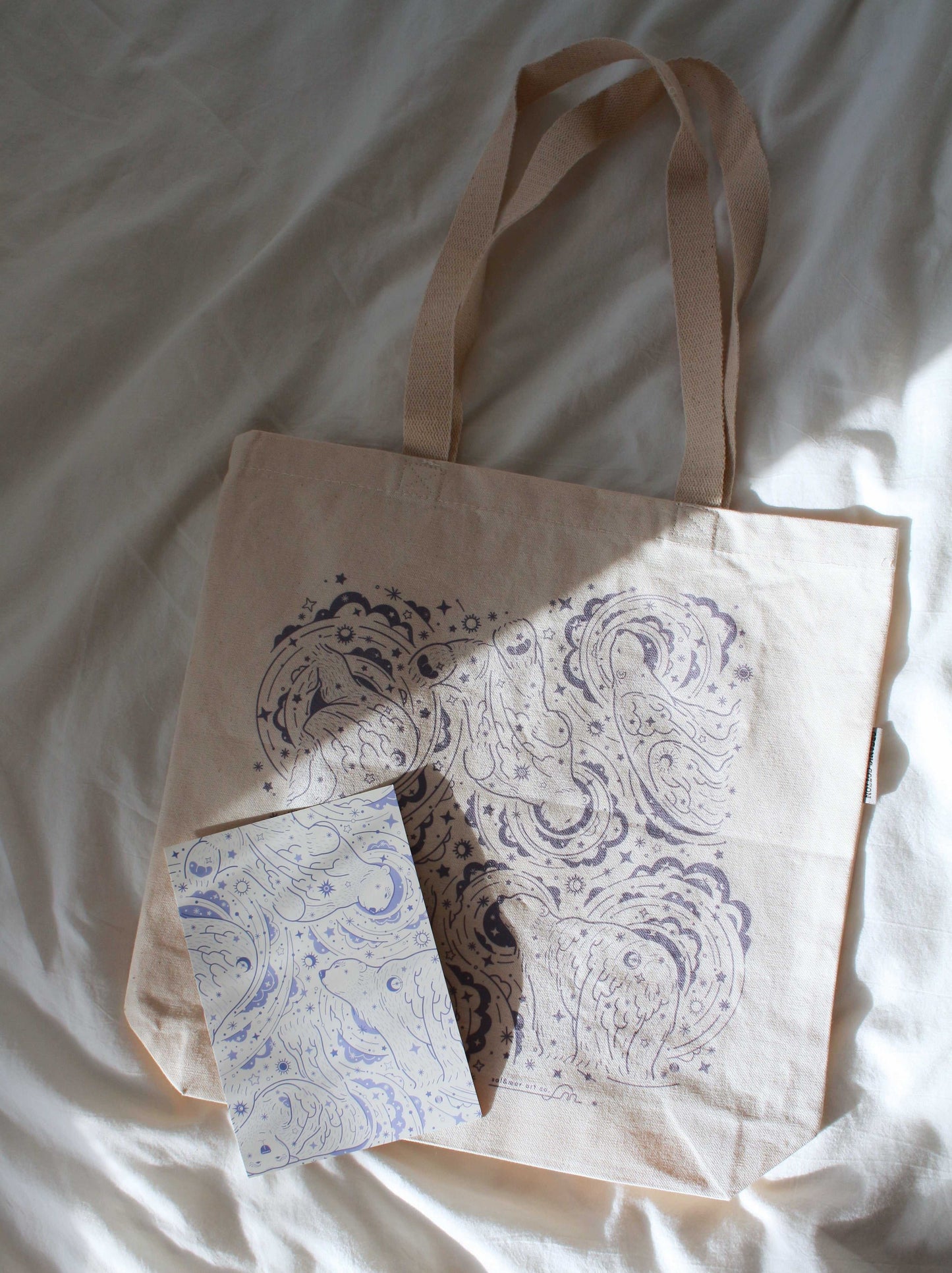 Polar Bear and Northern Sky canvas tote bag with matching notebook on a soft surface.