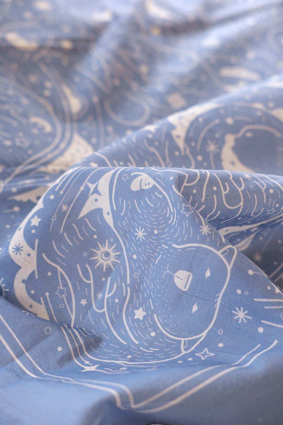 Close-up of a lavender bandana scarf featuring polar bears and Northern sky art design, highlighting soft cotton texture.