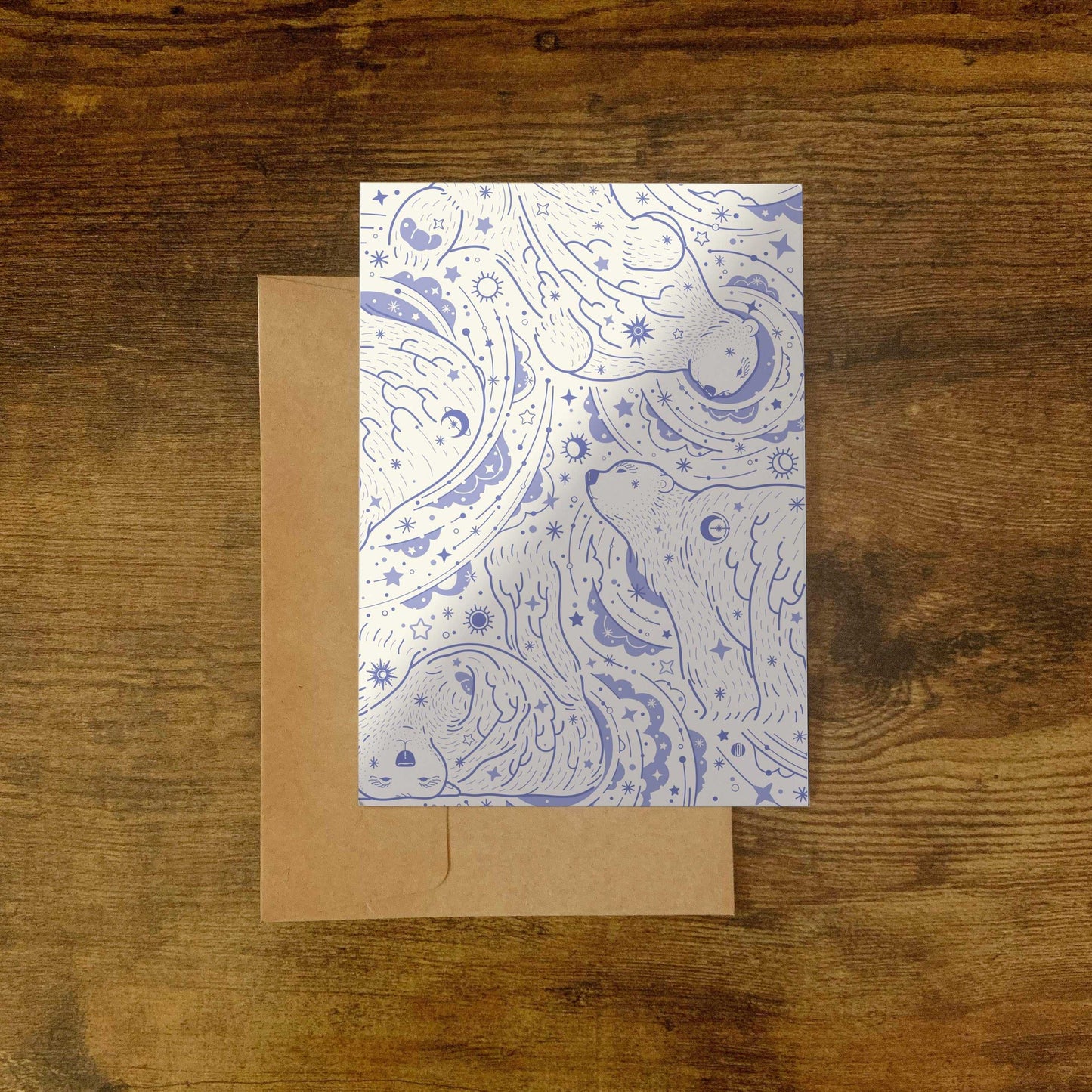 Polar bear illustration with stars and swirls on a silver card, laid on a brown envelope.