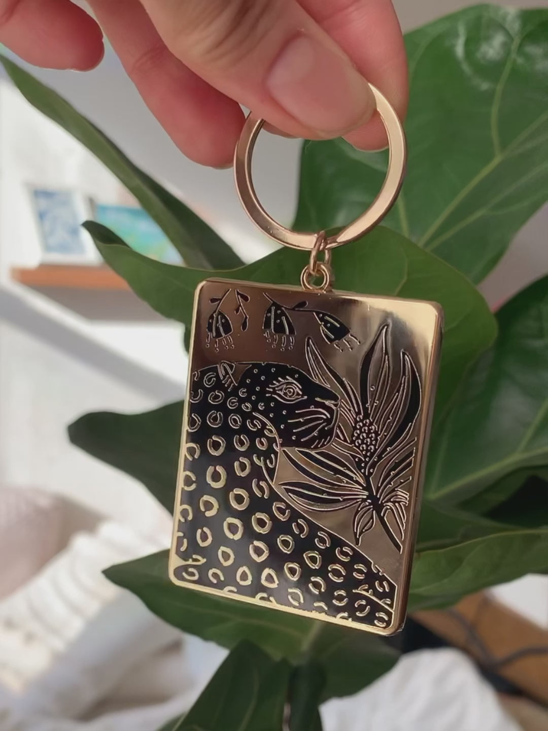 Leopard and flowers enamel keychain with gold-plated metal, detailed illustration and carabiner hanging option.