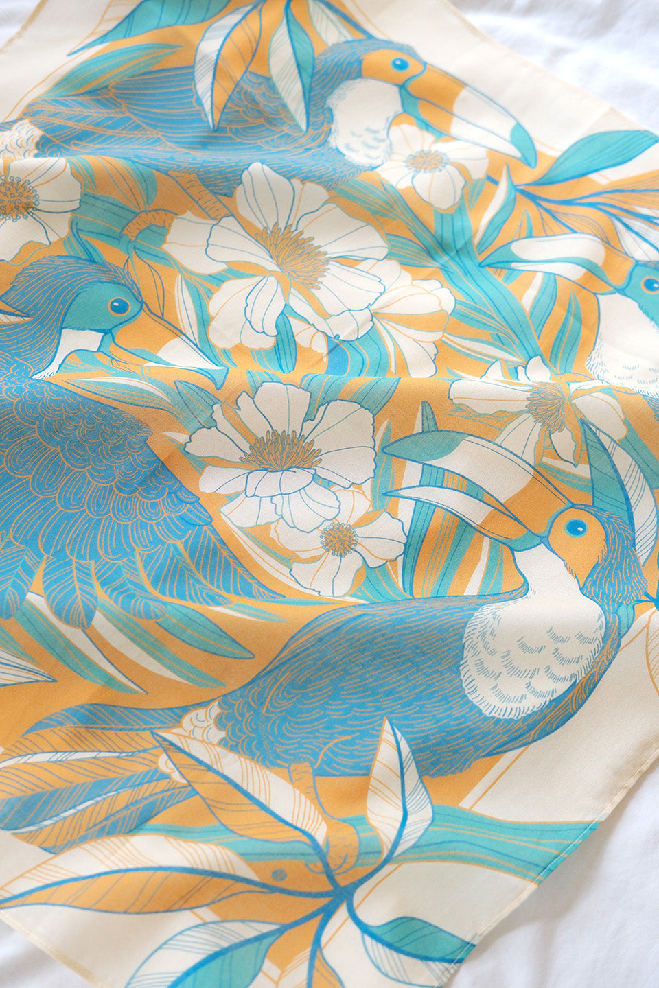 Toucan in a Floral Jungle Bandana Scarf featuring vibrant blue and yellow colors, perfect for accessories and decor.