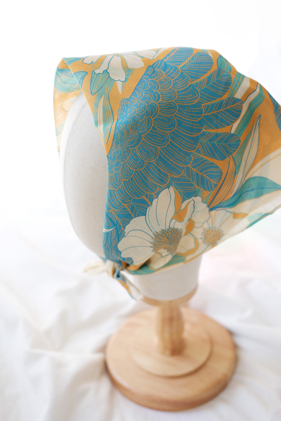 Toucan in Floral Jungle Bandana Scarf in yellow displayed on a mannequin head, featuring vibrant floral patterns.
