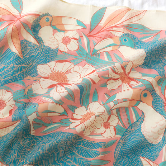 Toucan in Floral Jungle design on a pink bandana scarf featuring vibrant tropical flowers and leaves.