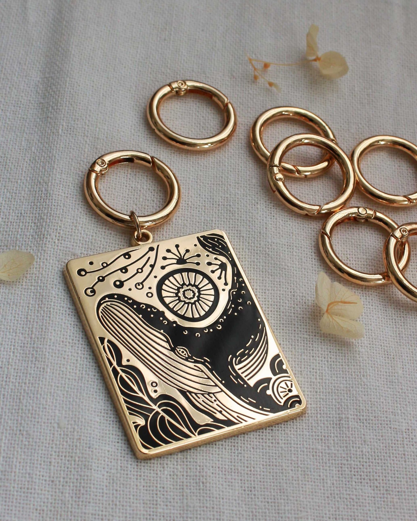 Humpback whale and ocean enamel keychain with gold plating and intricate design, displayed with metal rings.