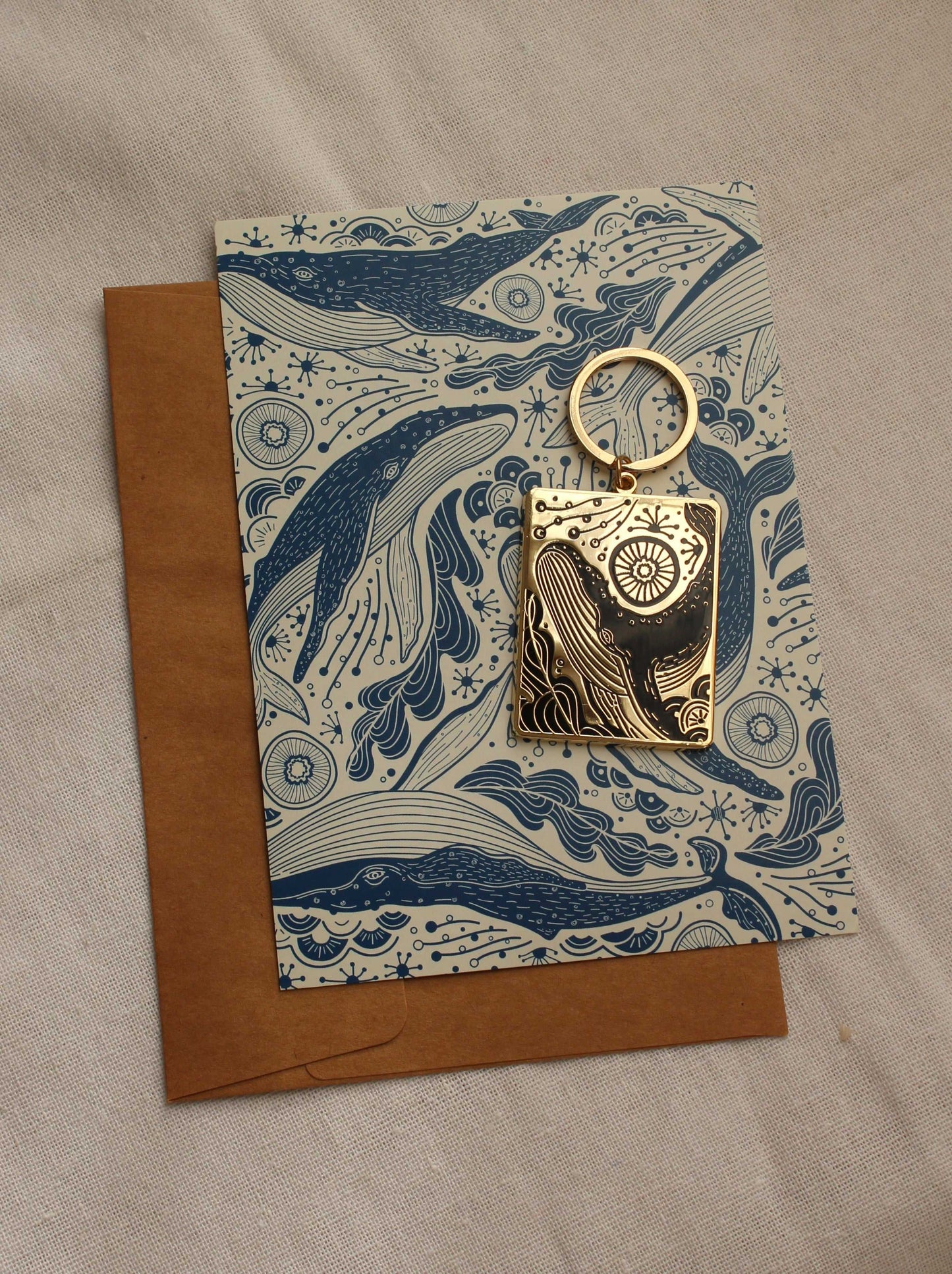 Humpback whale enamel keychain on illustrated ocean-themed display card.