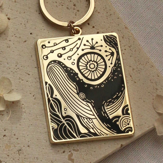 Humpback whale enamel keychain with ocean design, gold plated metal, rectangular charm, 2.25 inches.