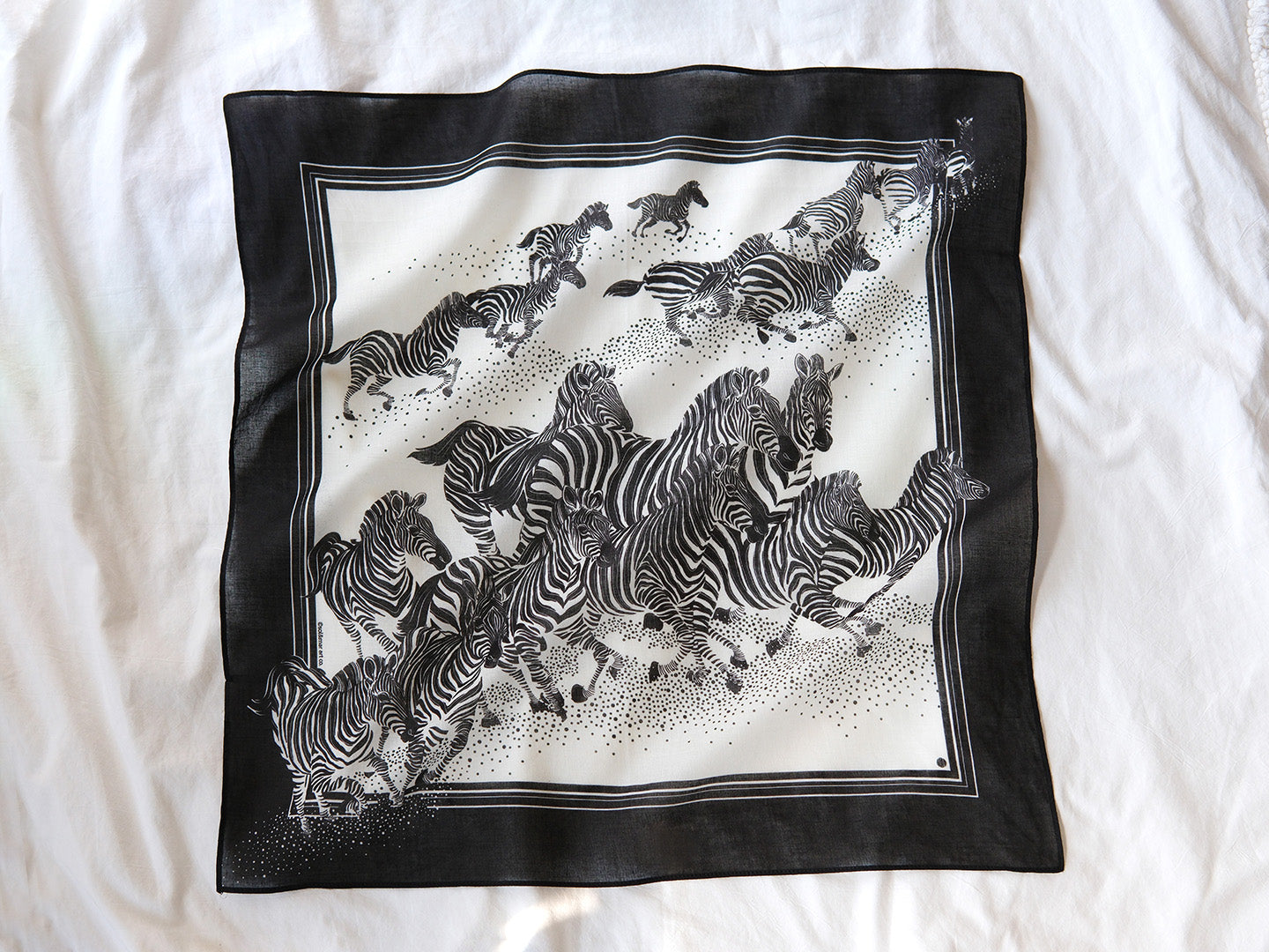 Black and white bandana scarf featuring a herd of zebras running, perfect as a fashion accessory or pet scarf.
