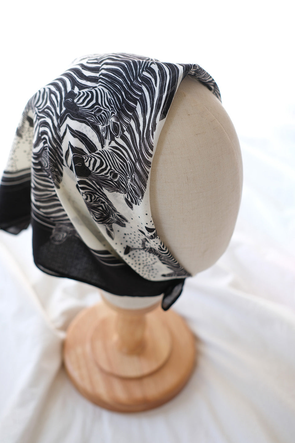 Zebra 'New Beginning' bandana scarf displayed on a mannequin, featuring black and white zebra art.