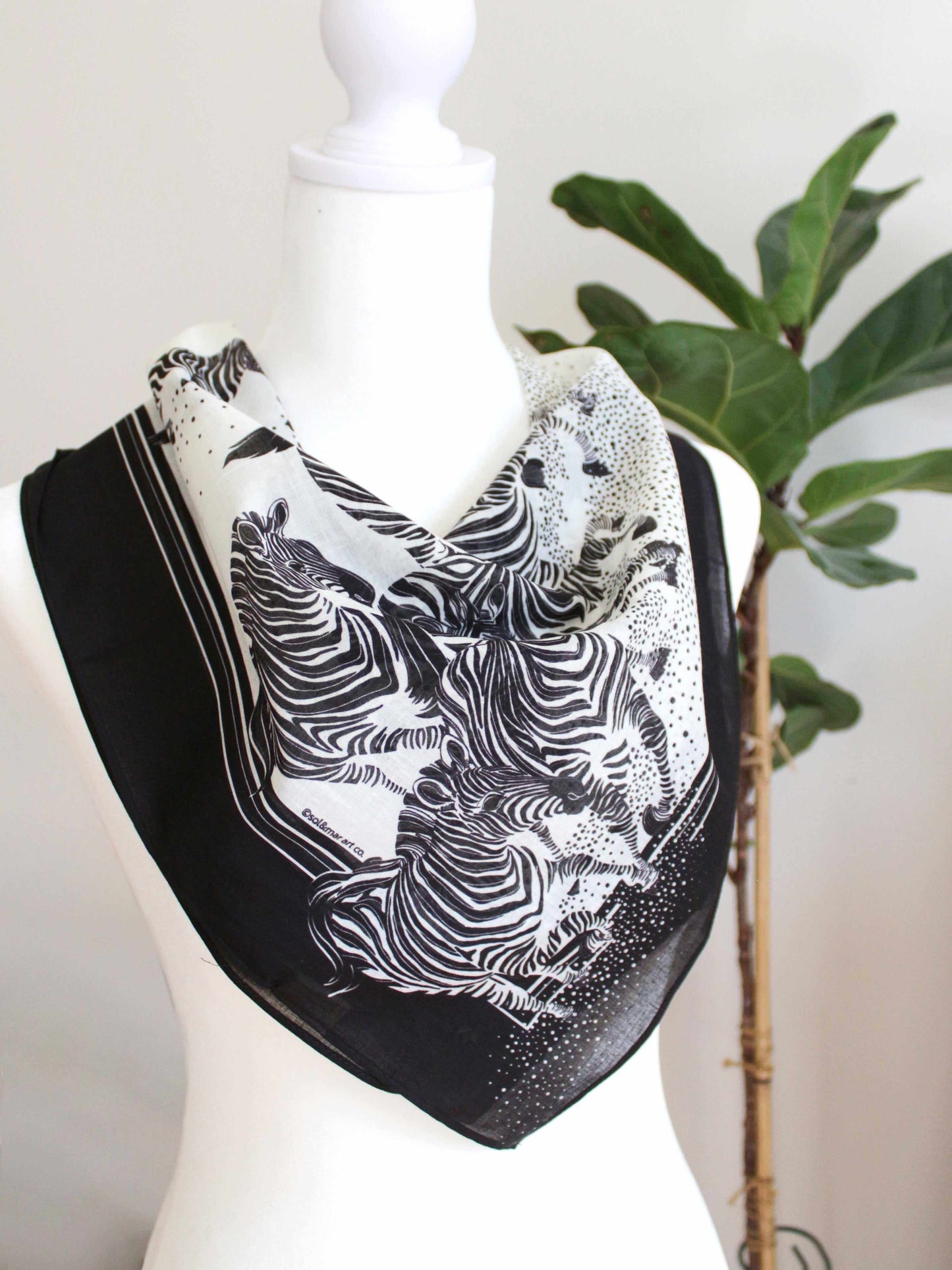 Artistic black and white zebra bandana scarf displayed on a mannequin, perfect for hair, bags, and pets.