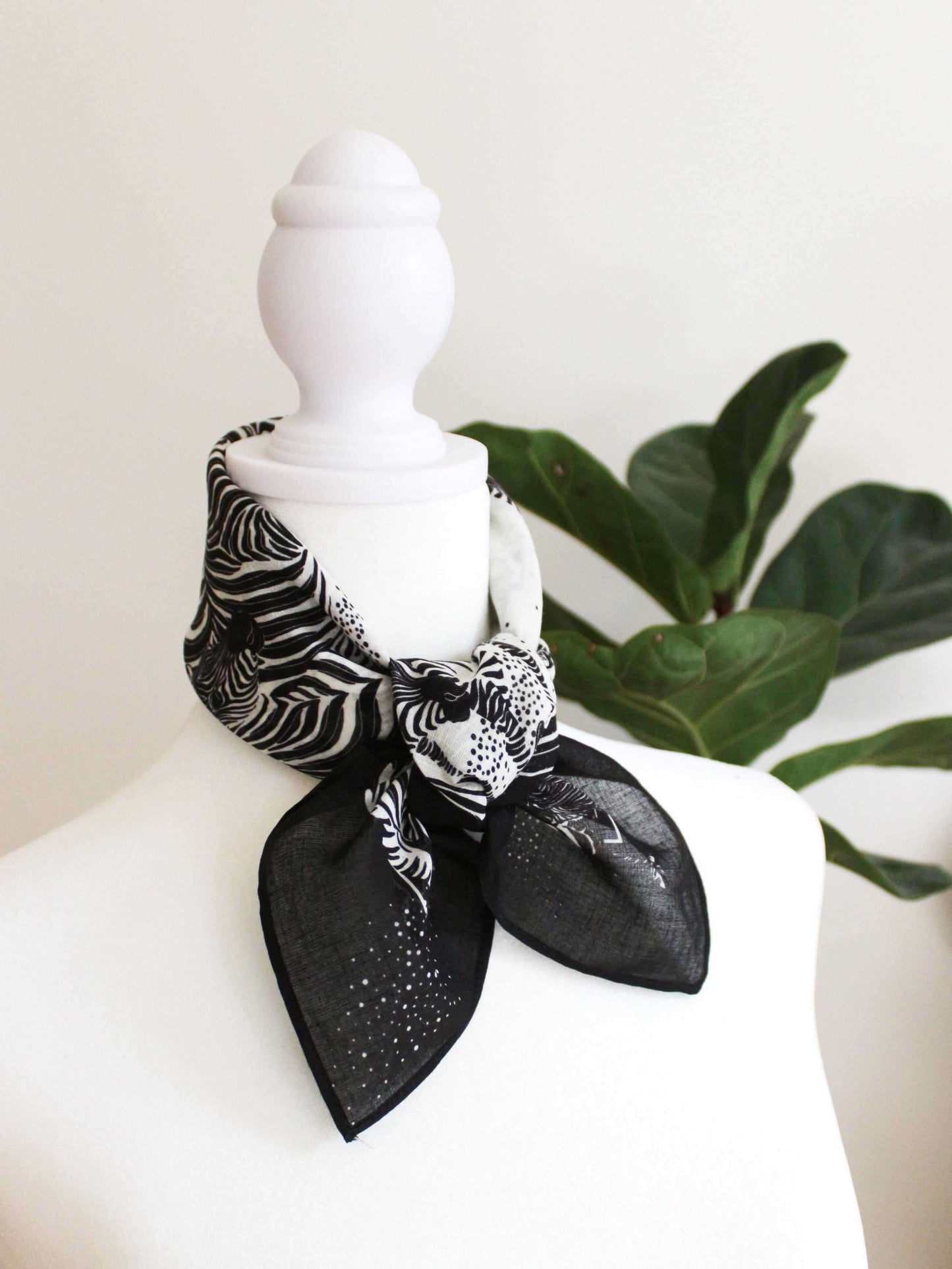 Stylish black and white zebra print bandana scarf tied on a mannequin, perfect for hair or accessory use.