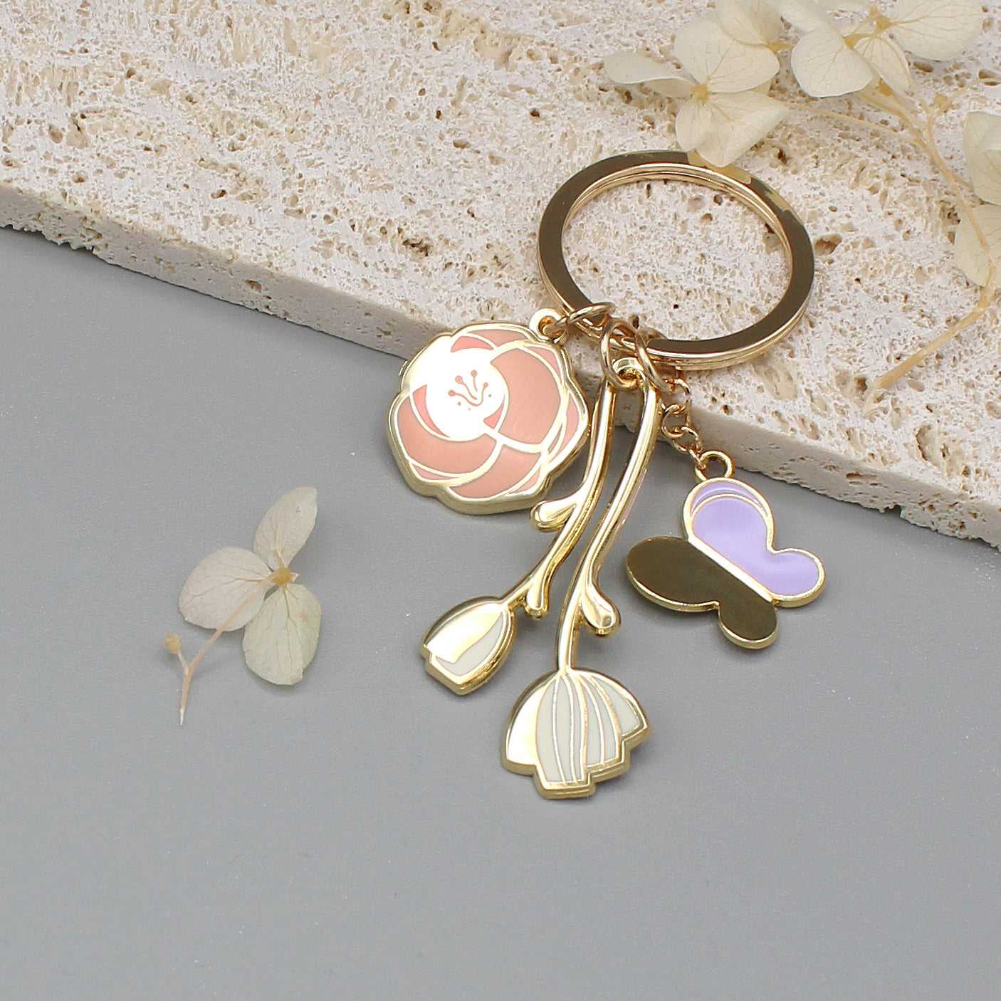 Minimal Garden Keychain featuring gold-plated flower and butterfly charms on a simple display card.