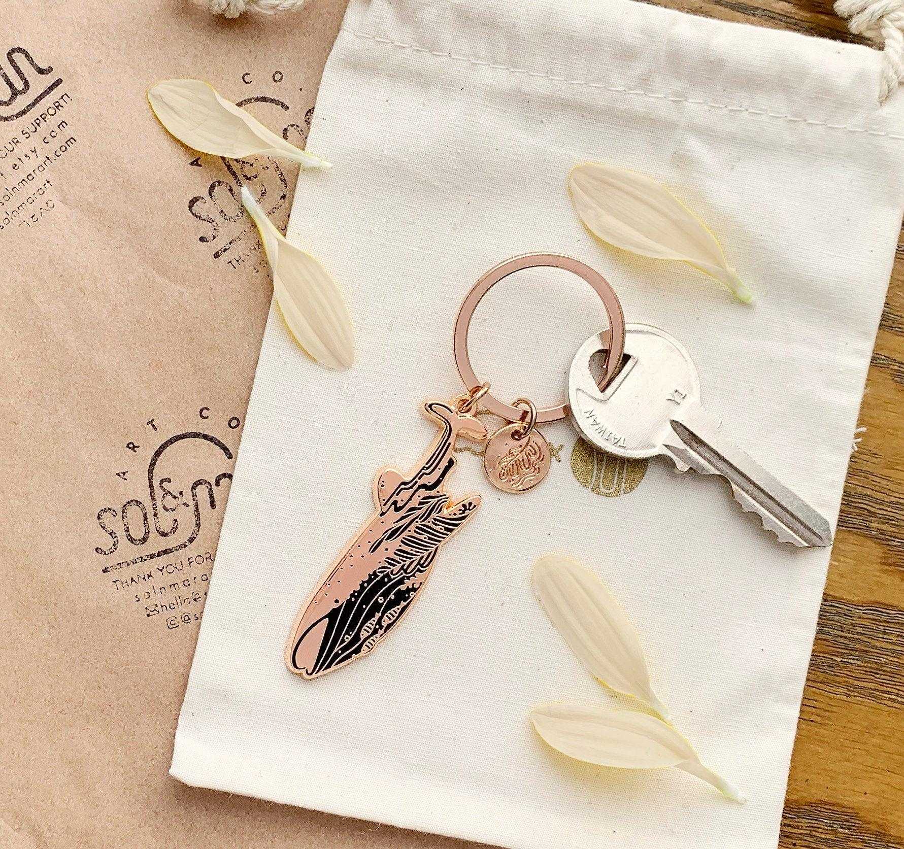 Whale Shark enamel keychain on a cloth bag with dried petals, promoting awareness of endangered species.