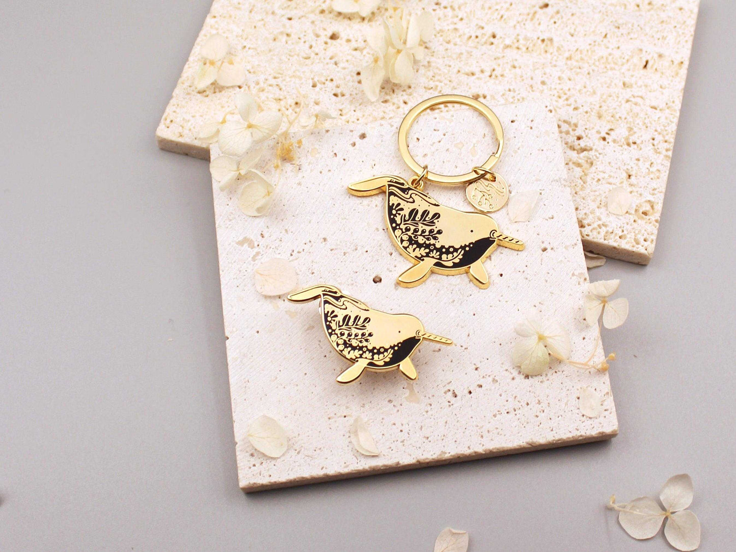 Narwhal enamel keychain with delicate line art and charm, promoting awareness for endangered animals.