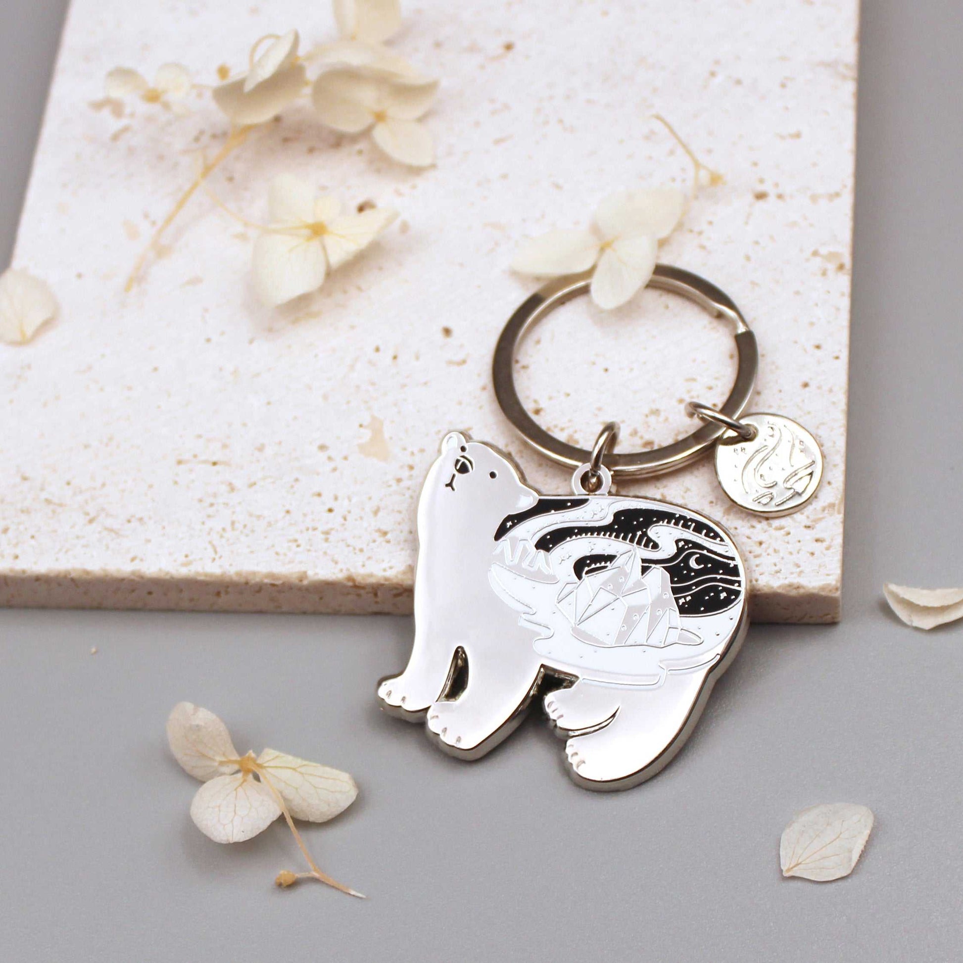 Polar bear enamel keychain featuring habitat art and organic round tag, promoting WWF for endangered species.