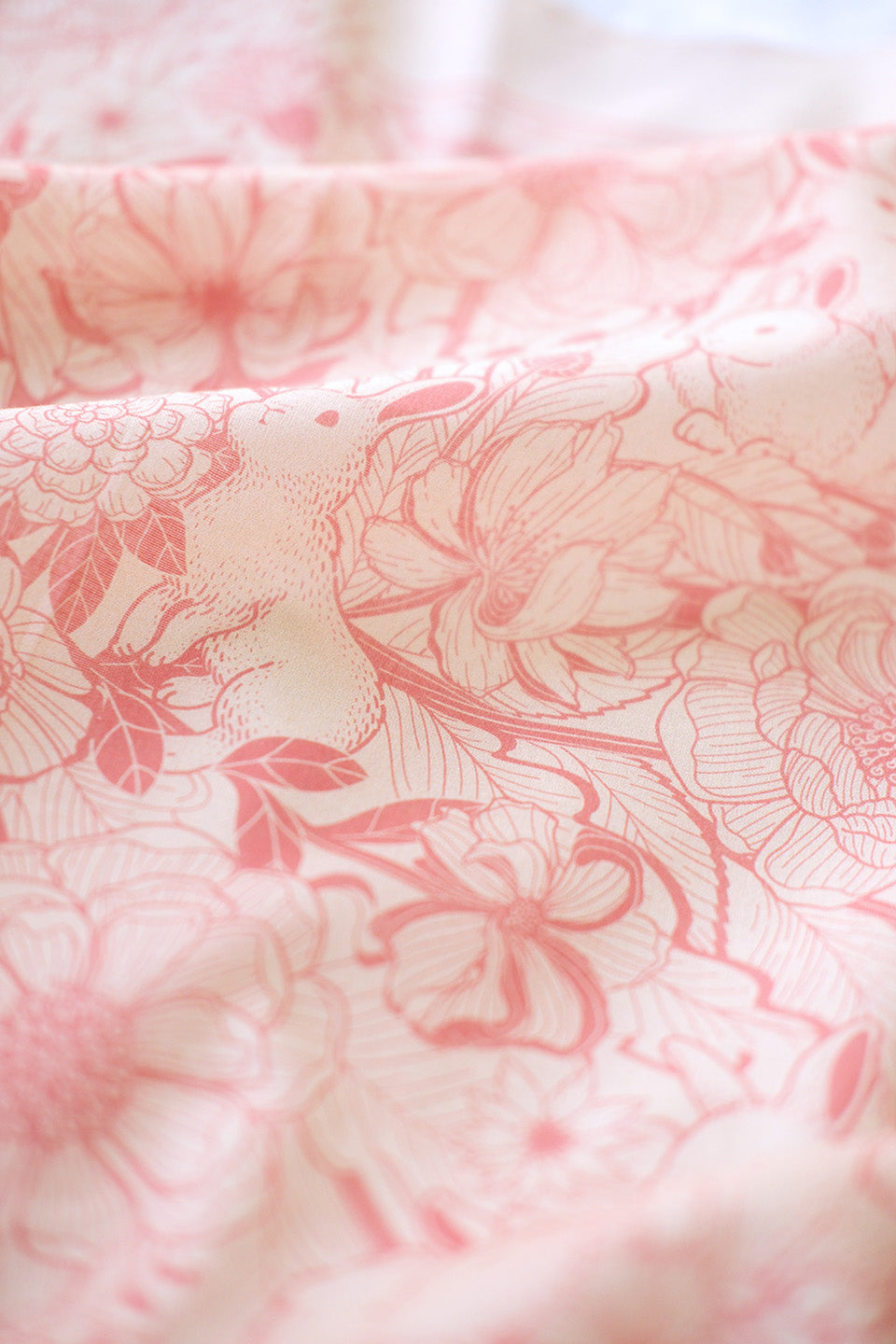 Pastel pink bandana scarf featuring rabbits and floral designs, perfect for hair or pet accessories.