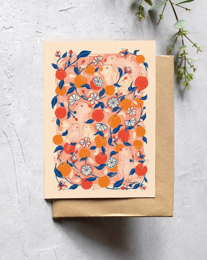Greeting card with citrus capybara design on a textured surface