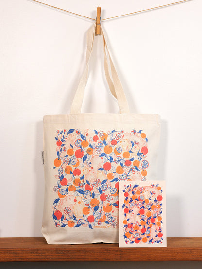 Tote bag with capybara & yuzu orange  design hanging on a wooden surface