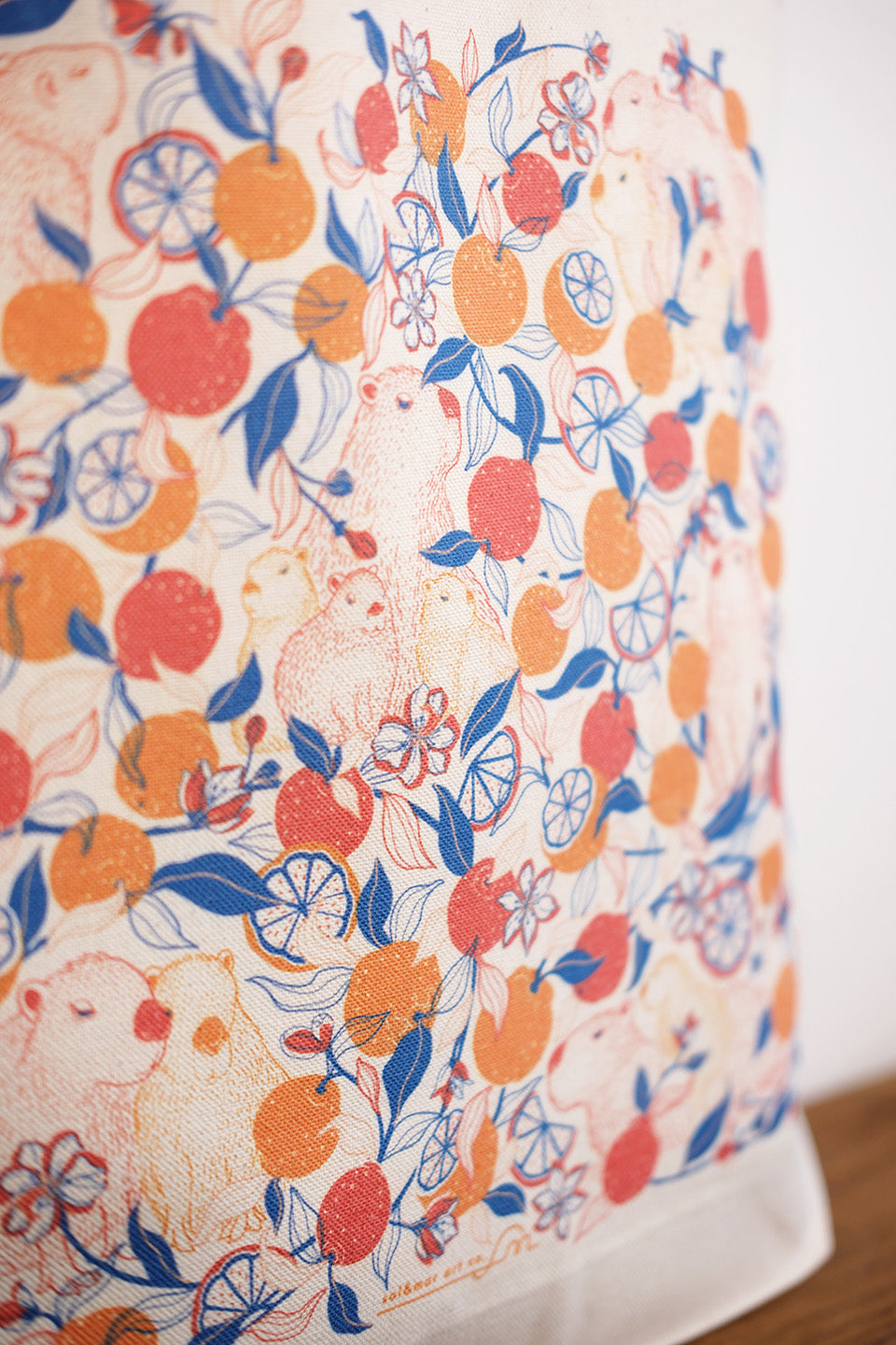 Fabric with a colorful capybara & yuzu orange  pattern of fruits and leaves on a white background