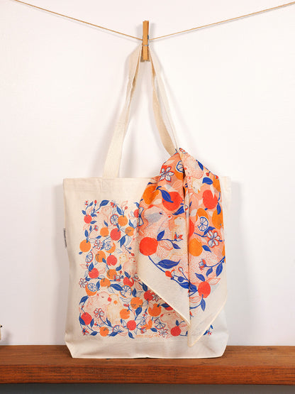 capybara & yuzu orange-patterned bag draped over a wooden surface with a white background