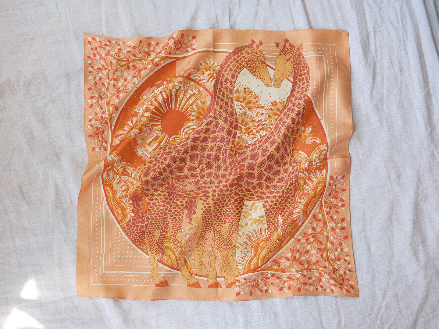 Decorative scarf with giraffe design on a white background